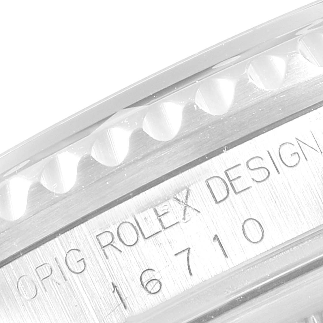 The image shows a close-up of the case side and part of the bezel of a Rolex GMT-Master 16710 Men
s Stainless Steel Black Dial 16710 Men
s Stainless Steel Black Dial model 16710.