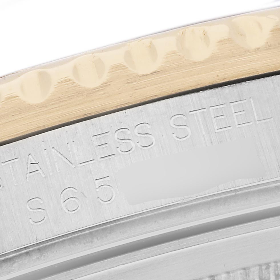 The image shows a close-up of the Rolex GMT-Master 16713 Men's Steel and Gold (two tone) Black Dial 16713 Men's Steel and Gold (two tone) Black Dial’s stainless steel case edge and bezel.