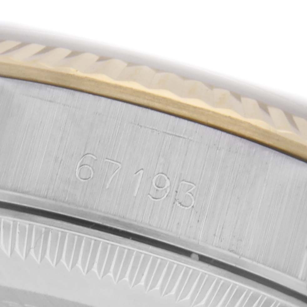 The image shows a close-up of the Rolex Oyster Perpetual 67193 Women's Steel and Gold (two tone) Champagne Dial 67193 Women's Steel and Gold (two tone) Champagne Dial's side, highlighting the bezel and engraved numbers.