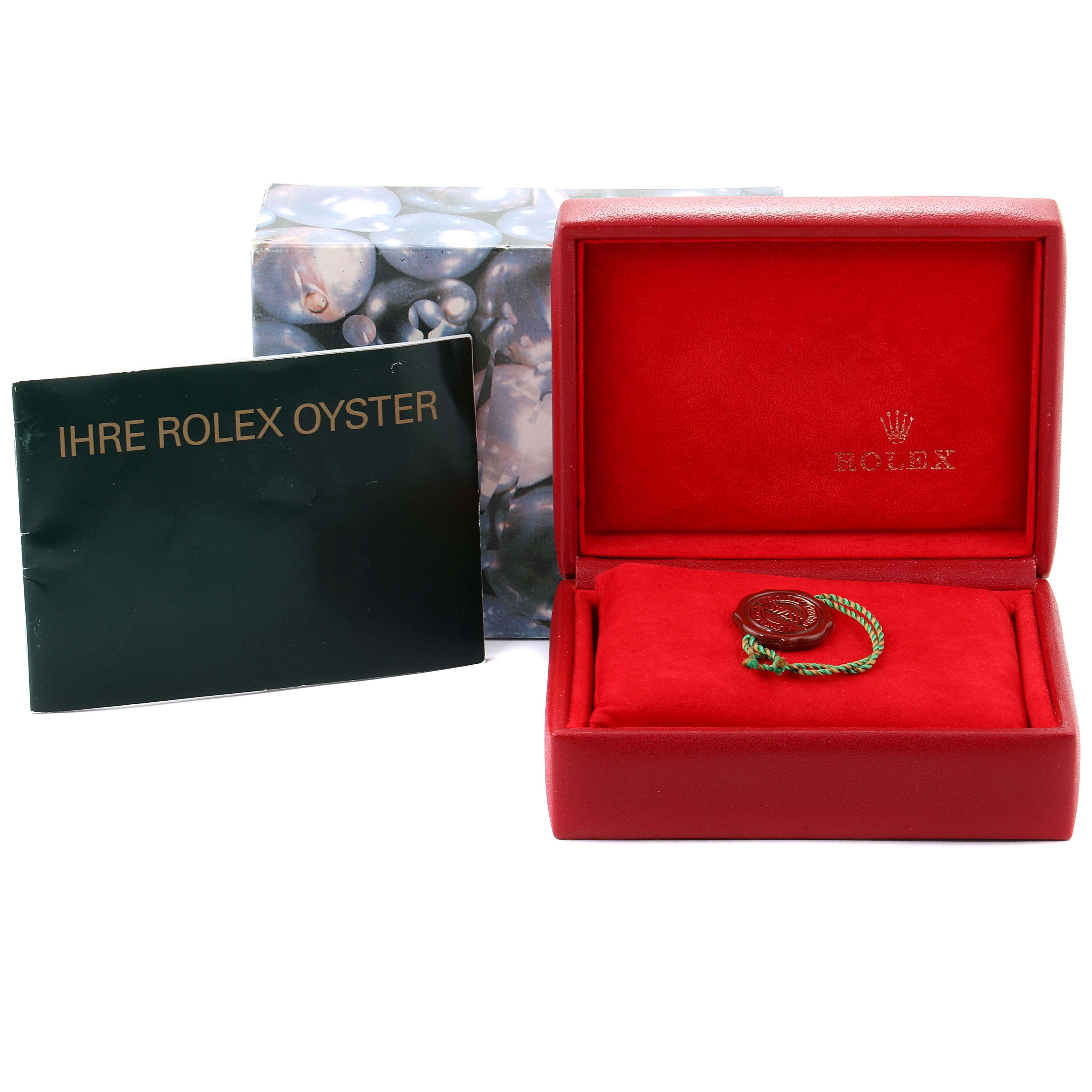 The image shows an open red Rolex box for the Oyster Perpetual, along with a booklet and a Rolex tag.