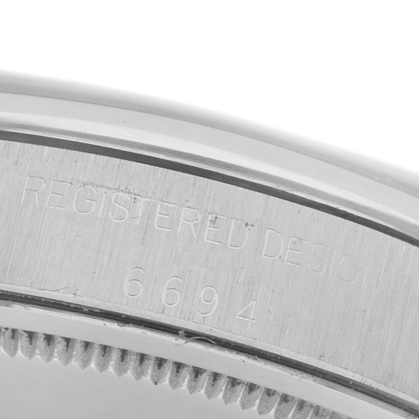 The image shows a close-up of the engraving on the case back edge of a Rolex Date 6694 Men's Stainless Steel Silver Dial 6694 Men's Stainless Steel Silver Dial model.