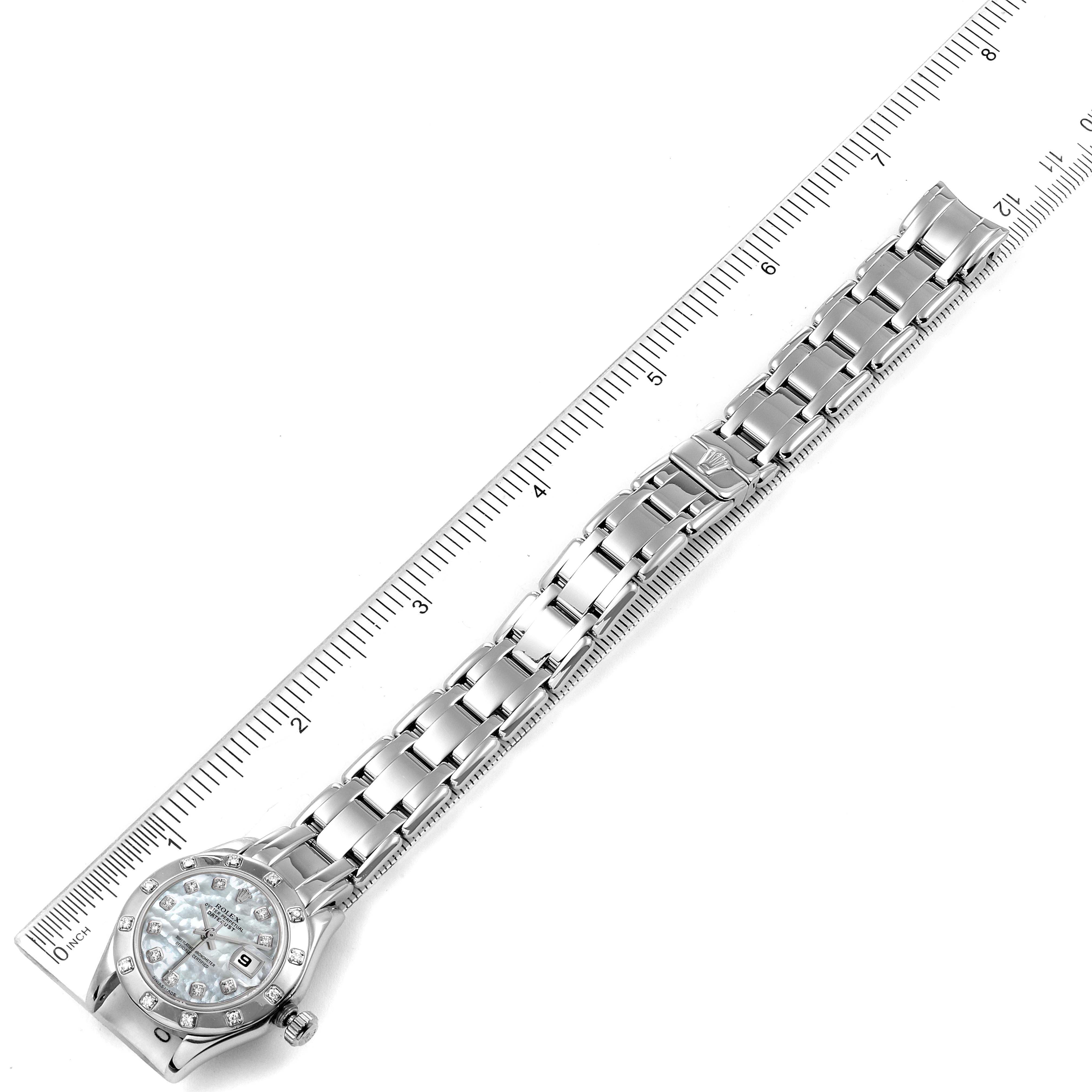 The image shows a top view of a Rolex Pearlmaster 69319 Women's White Gold Mother of Pearl Dial 69319 Women's White Gold Mother of Pearl Dial watch, displaying the bracelet, dial, and bezel, alongside a ruler for scale.