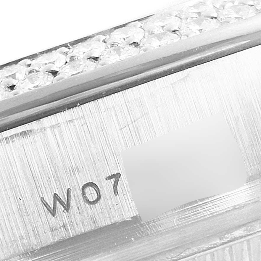 This image shows a close-up of a section of the Rolex Pearlmaster 69359 Women's White Gold Mother of Pearl Dial 69359 Women's White Gold Mother of Pearl Dial watch, focusing on its engraved serial number and bejewelled edge.