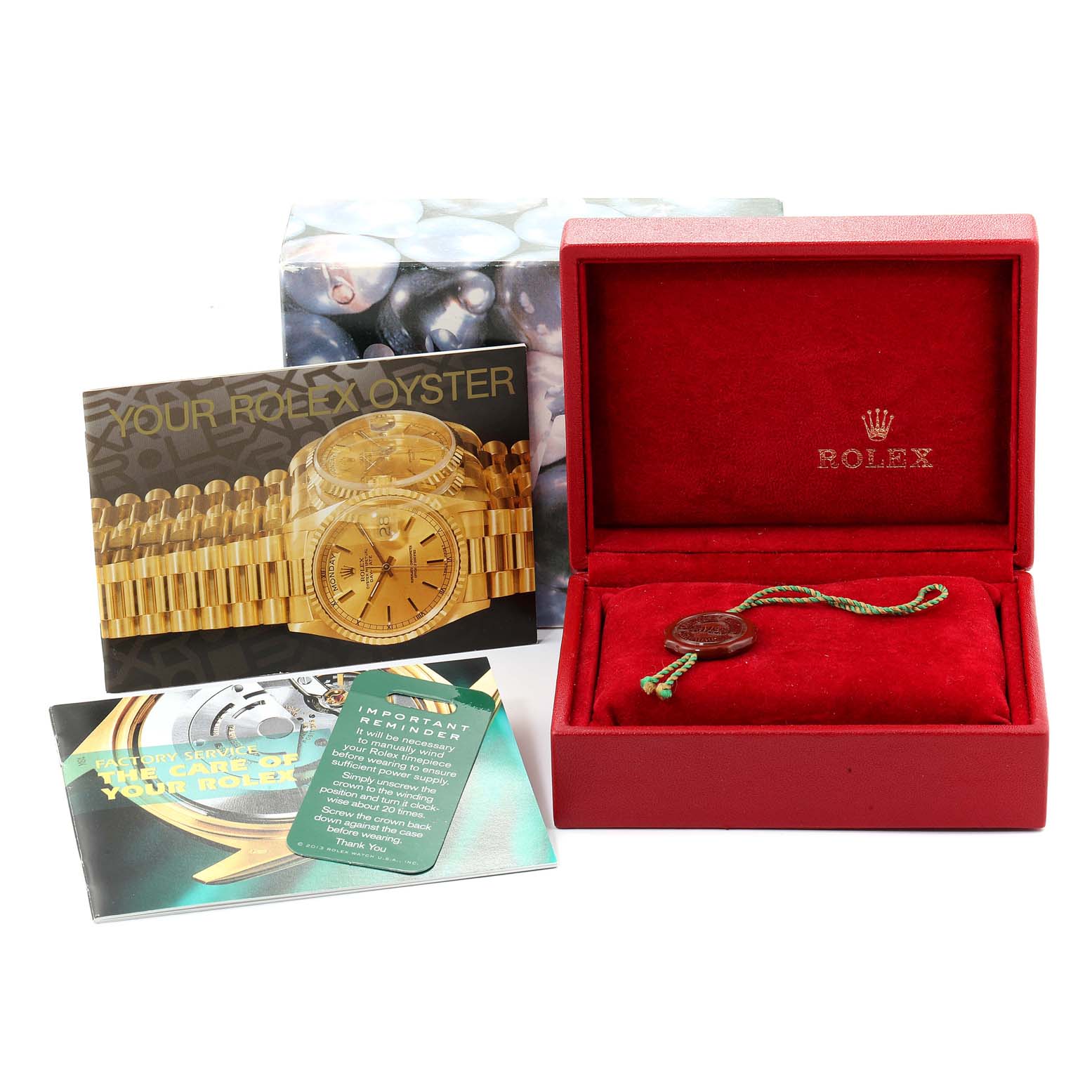 The image shows the accessories of a Rolex President 69288 Women
s Yellow Gold White Dial 69288 Women
s Yellow Gold White Dial watch, including the box, tag, and booklets from a straight-on angle.