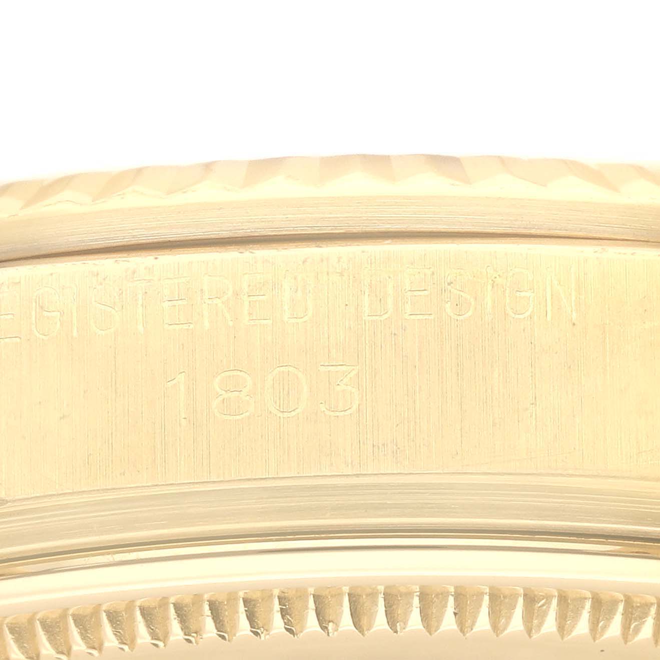The image shows a close-up of the side of a Rolex Vintage Collection 1803 Men's Yellow Gold Champagne Dial 1803 Men's Yellow Gold Champagne Dial watch, focusing on the engraved serial number and edge of the case.