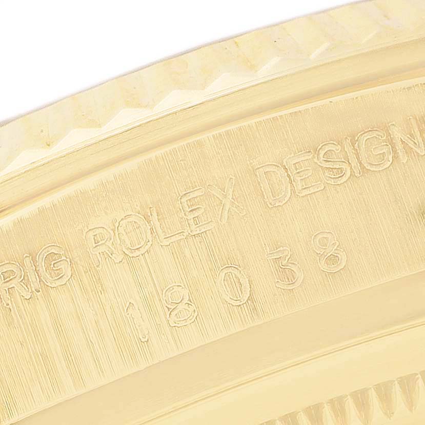 The image shows a close-up side view of the Rolex President 18038 Men's Yellow Gold Champagne Dial model bezel and inscription, highlighting the engravings.