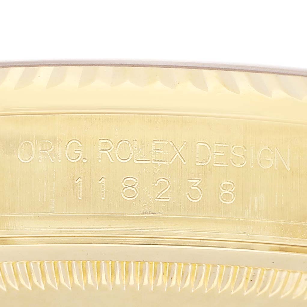 The image shows a close-up of the side of the case of a Rolex President 118238 Men's Yellow Gold Silver Dial model, highlighting the engraved model number and design details.