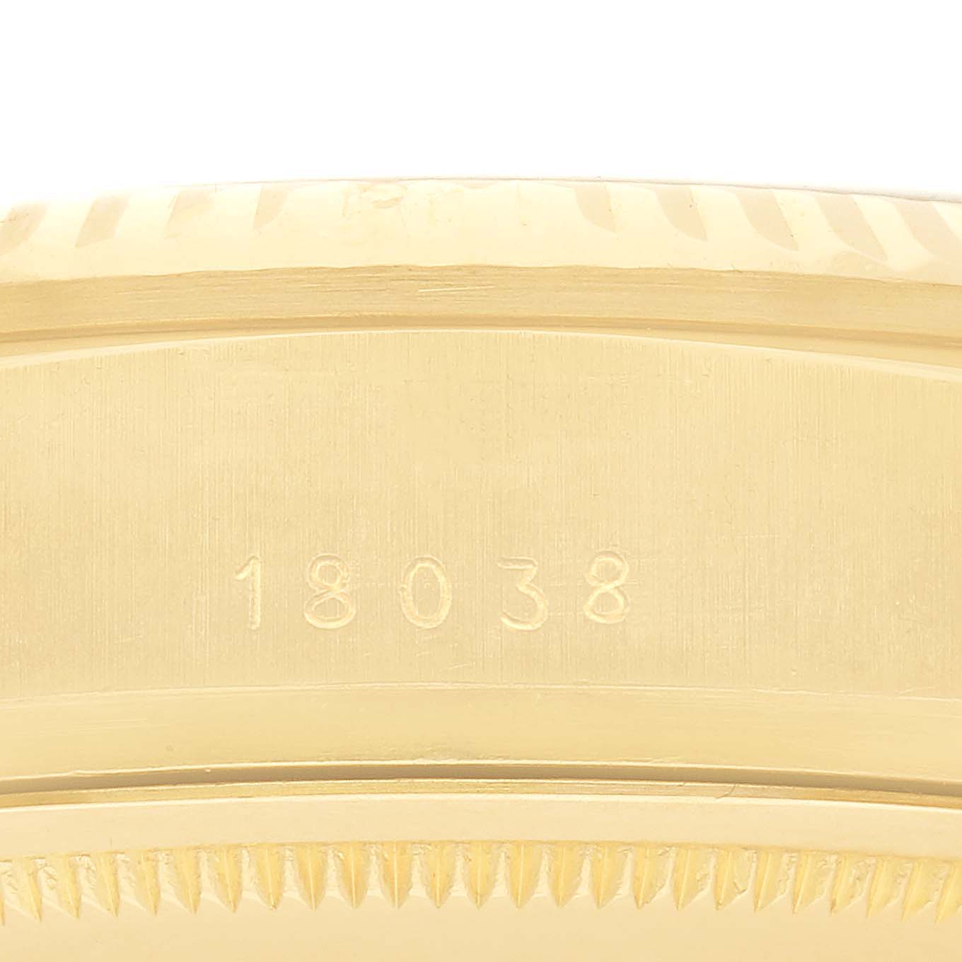 The image shows a close-up of the side of a Rolex President 18038 Men's Yellow Gold Champagne Dial 18038 Men's Yellow Gold Champagne Dial model, focusing on the case with engravings and part of the bezel.