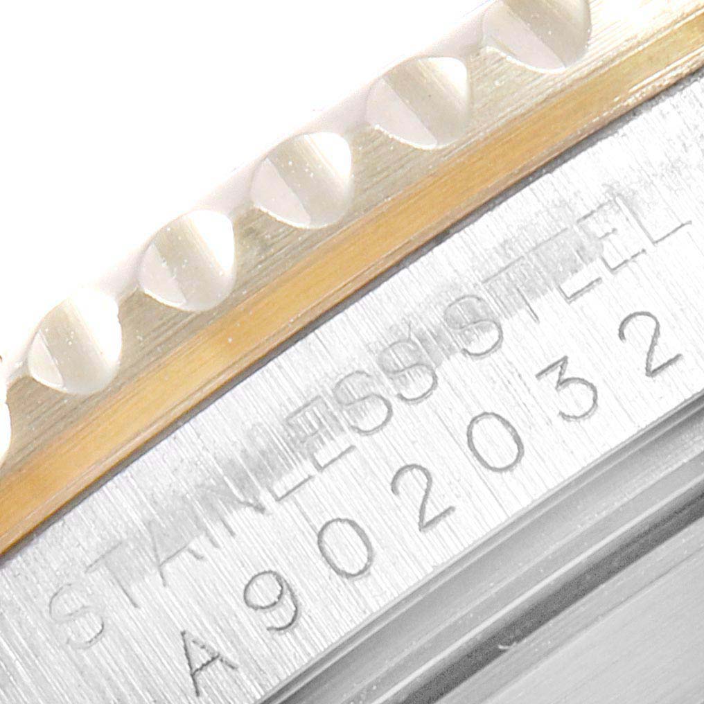 Close-up of the Rolex Submariner 16613 Men
s Steel and Gold (two tone) Blue Dial 16613 Men
s Steel and Gold (two tone) Blue Dial
s bezel edge and part of the case, showing engraved serial numbers and "STAINLESS STEEL" marking.