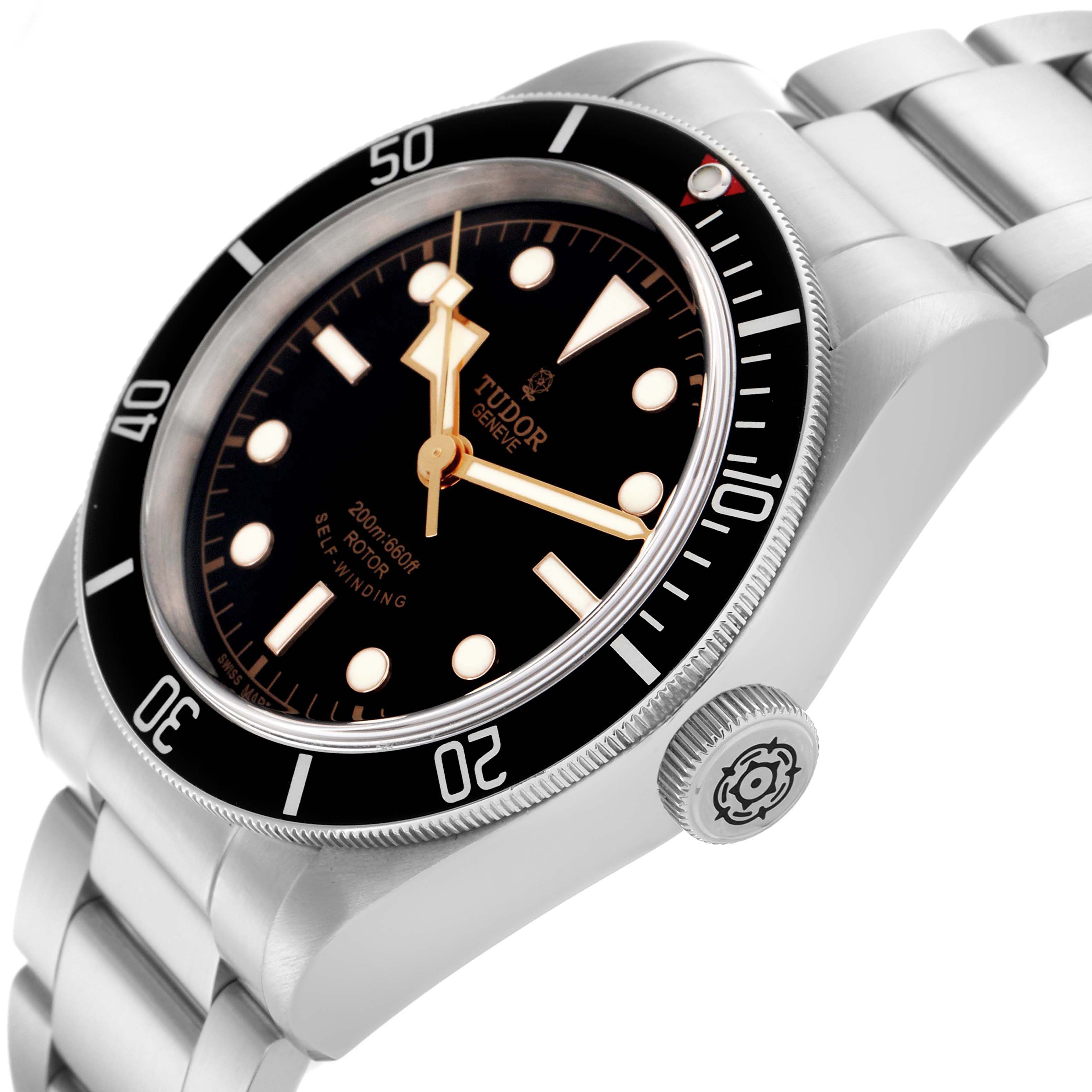 The Tudor Heritage Black Bay 79220N Men's Stainless Steel Black Dial 79220N Men's Stainless Steel Black Dial watch is shown at an angle highlighting the case, bezel, bracelet, and winding crown.