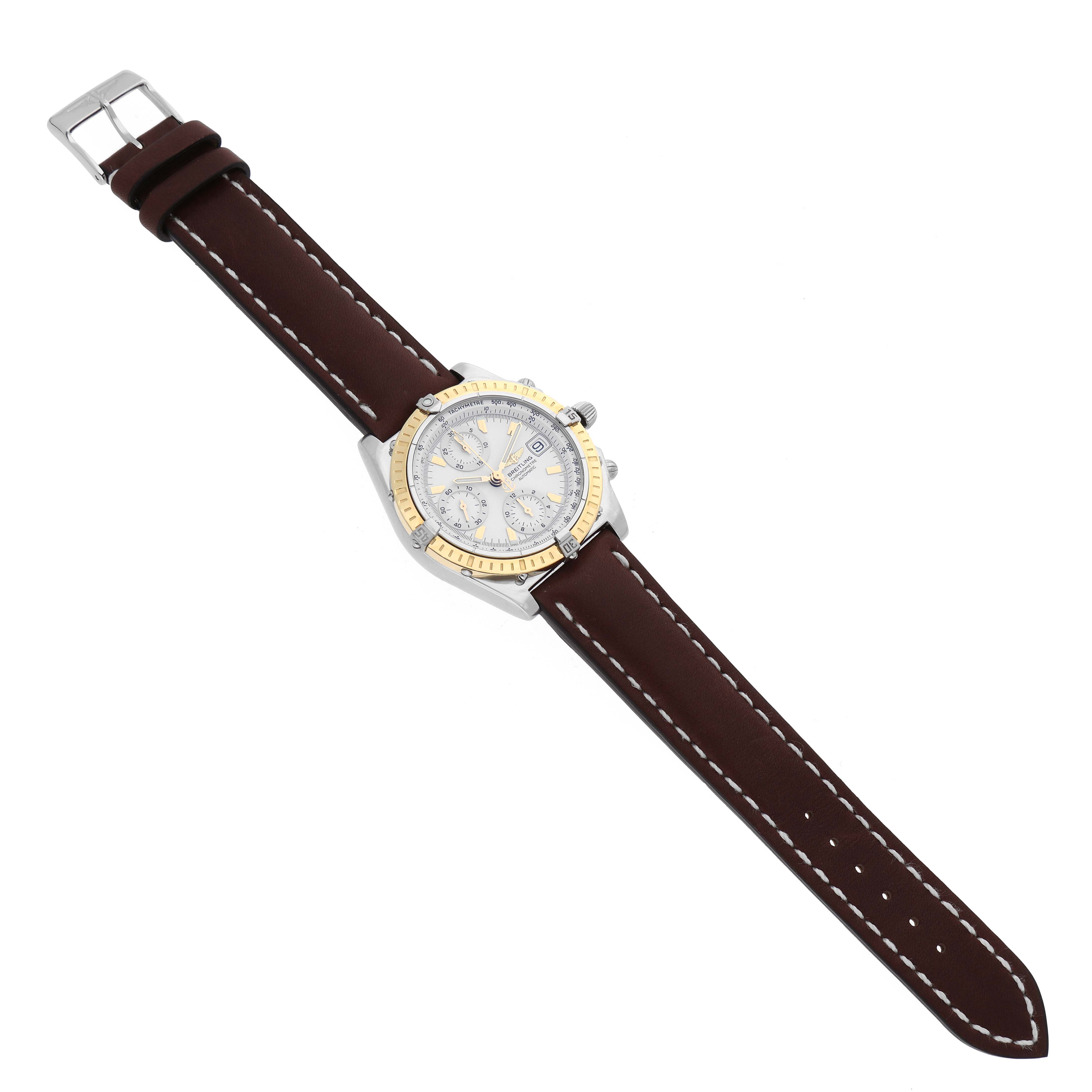 This image shows a Breitling Chronomat D1335212/A538 Men
s Stainless Steel White Dial D1335212/A538 Men
s Stainless Steel White Dial watch from a top-down angle, highlighting the face, bezel, and the full leather strap.