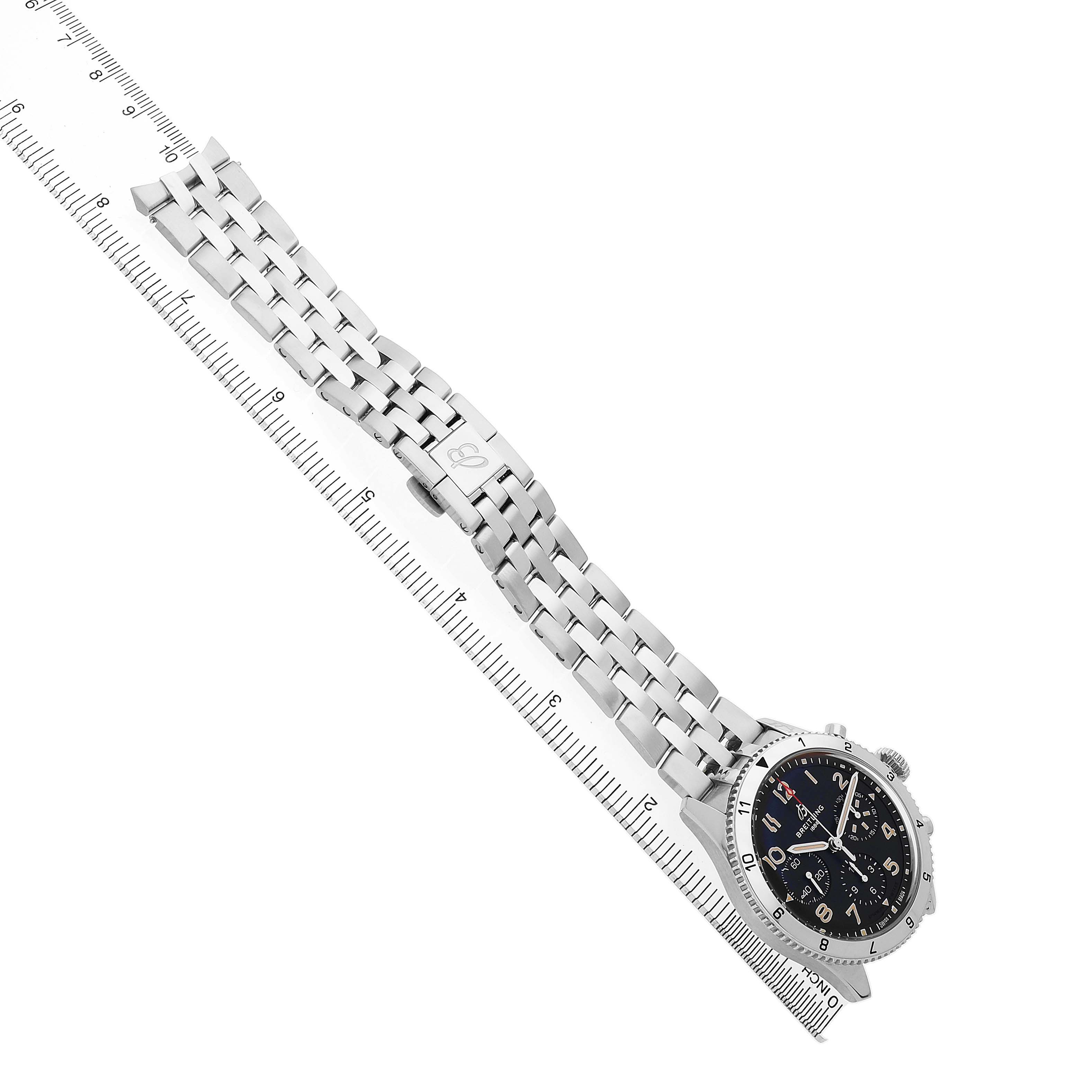 The Breitling Aviator A23380 Men's Stainless Steel Black Dial watch is shown at an angle displaying its dial and metal bracelet alongside a ruler for scale.