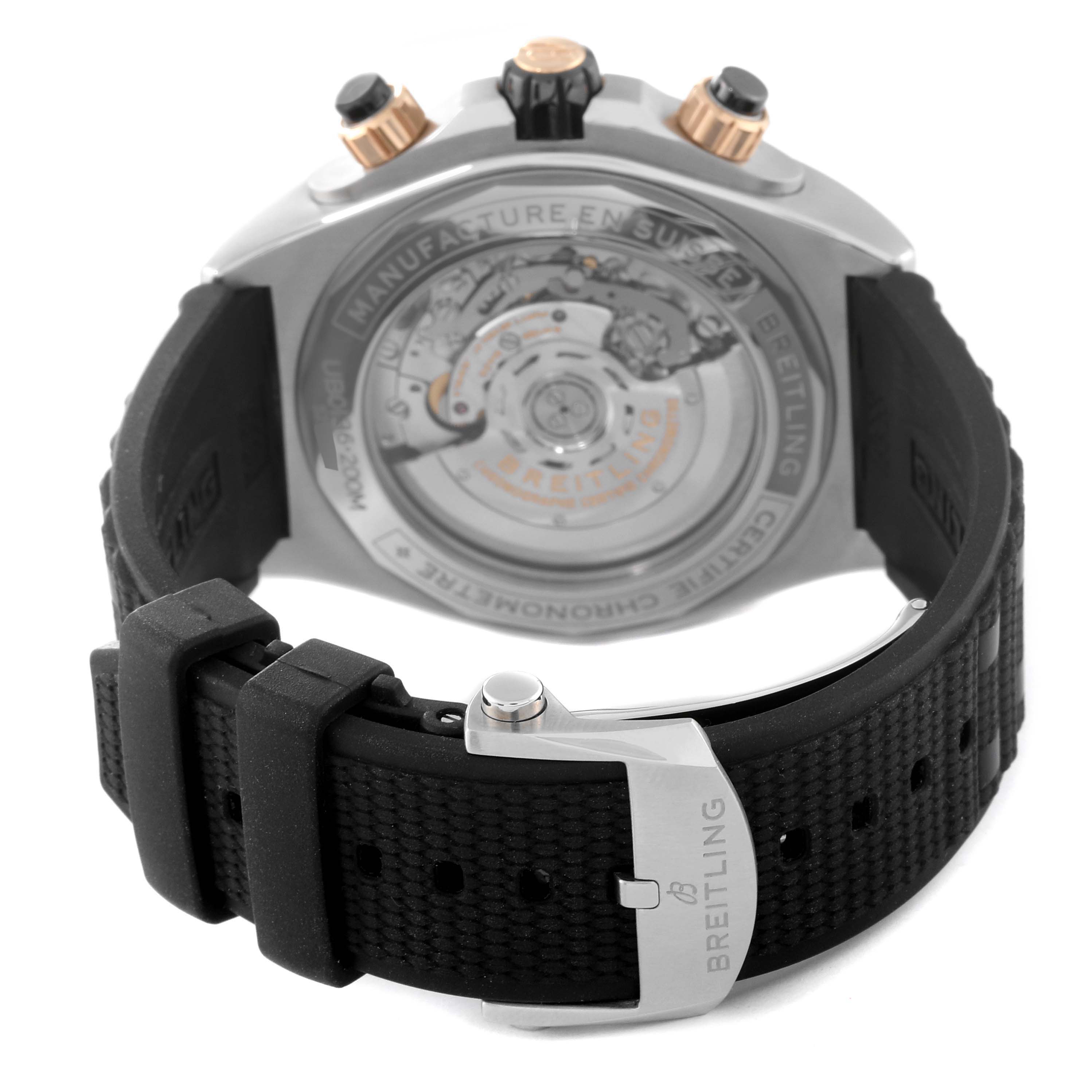 The image shows the back and clasp of a Breitling Chronomat UB0136251L1S1 Men's Steel and Gold (two tone) Green Dial UB0136251L1S1 Men's Steel and Gold (two tone) Green Dial watch, highlighting the movement and rubber strap.