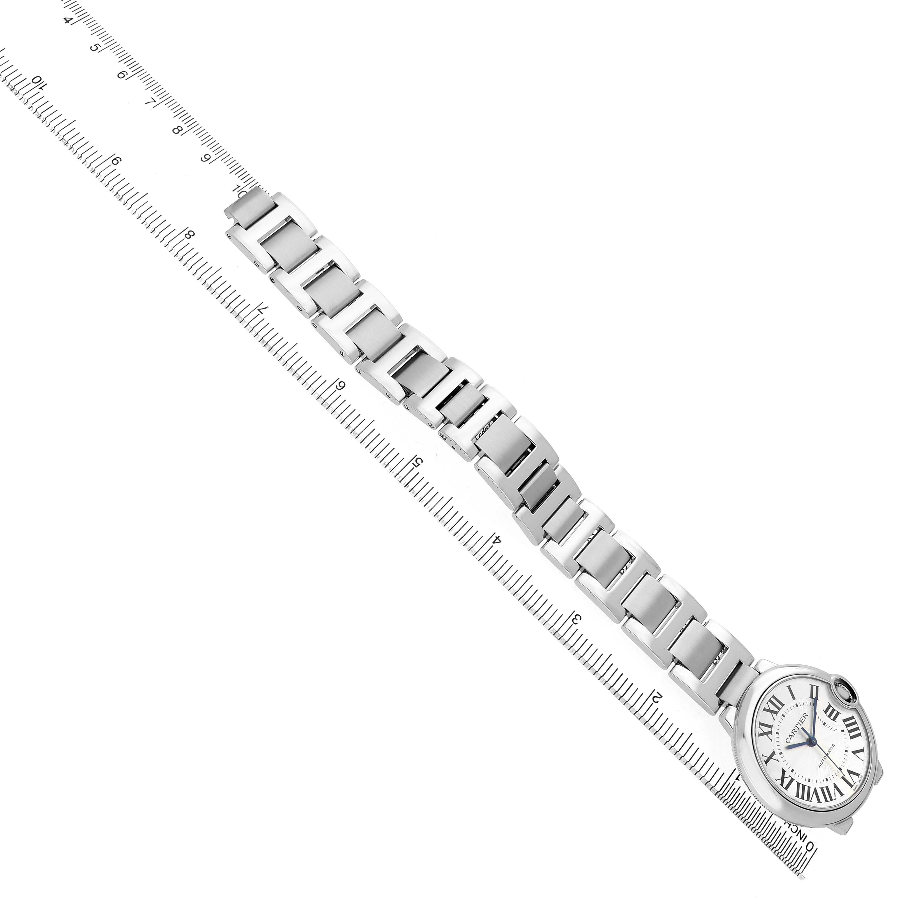 The Cartier Ballon Bleu W6920046 Women's Stainless Steel Silver Dial watch is shown at a slight angle, featuring the full bracelet and dial alongside a ruler for scale.