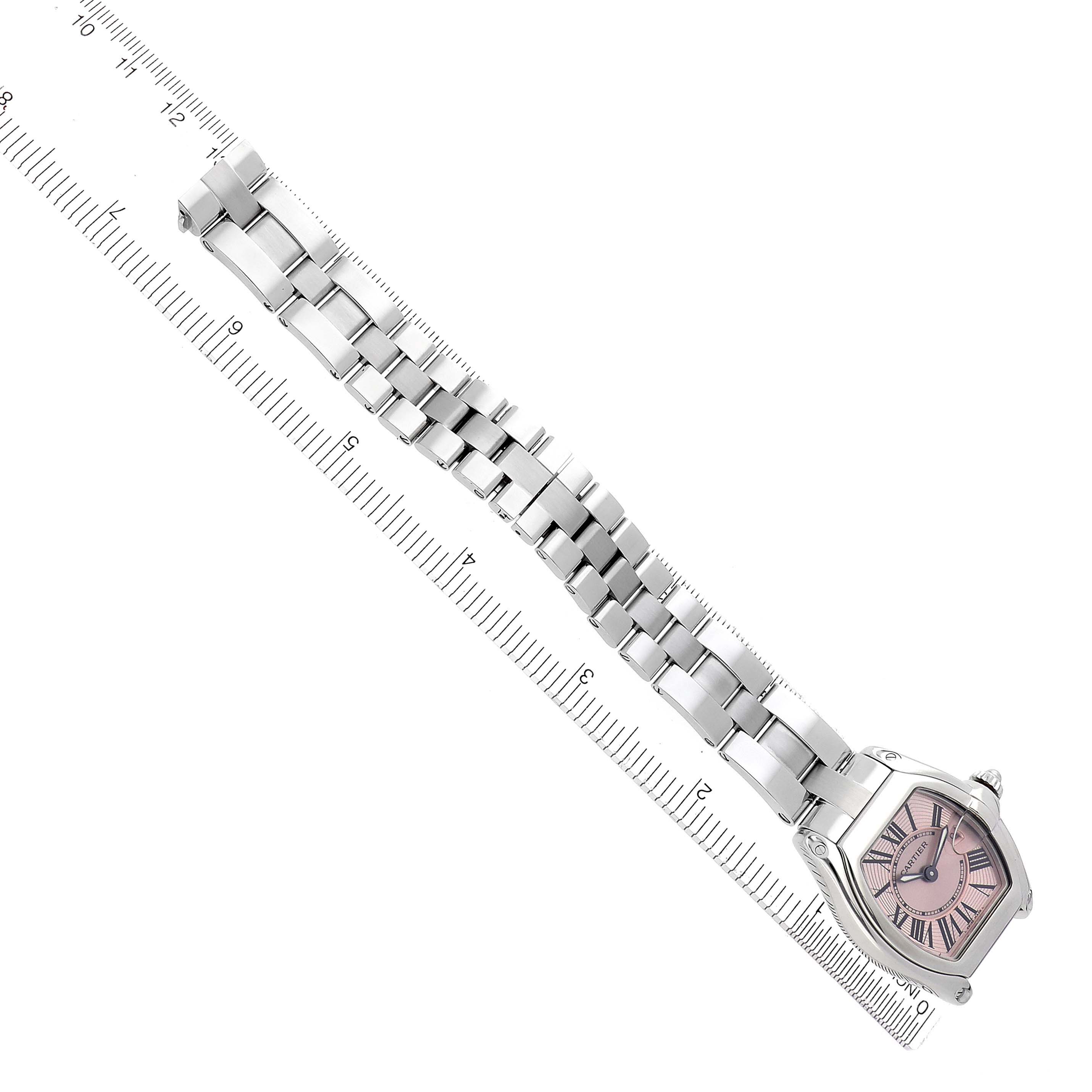 The Cartier Roadster W62017V3 Women's Stainless Steel Pink Dial W62017V3 Women's Stainless Steel Pink Dial watch is shown from an overhead angle, displaying the watch face and full metal bracelet alongside a ruler.