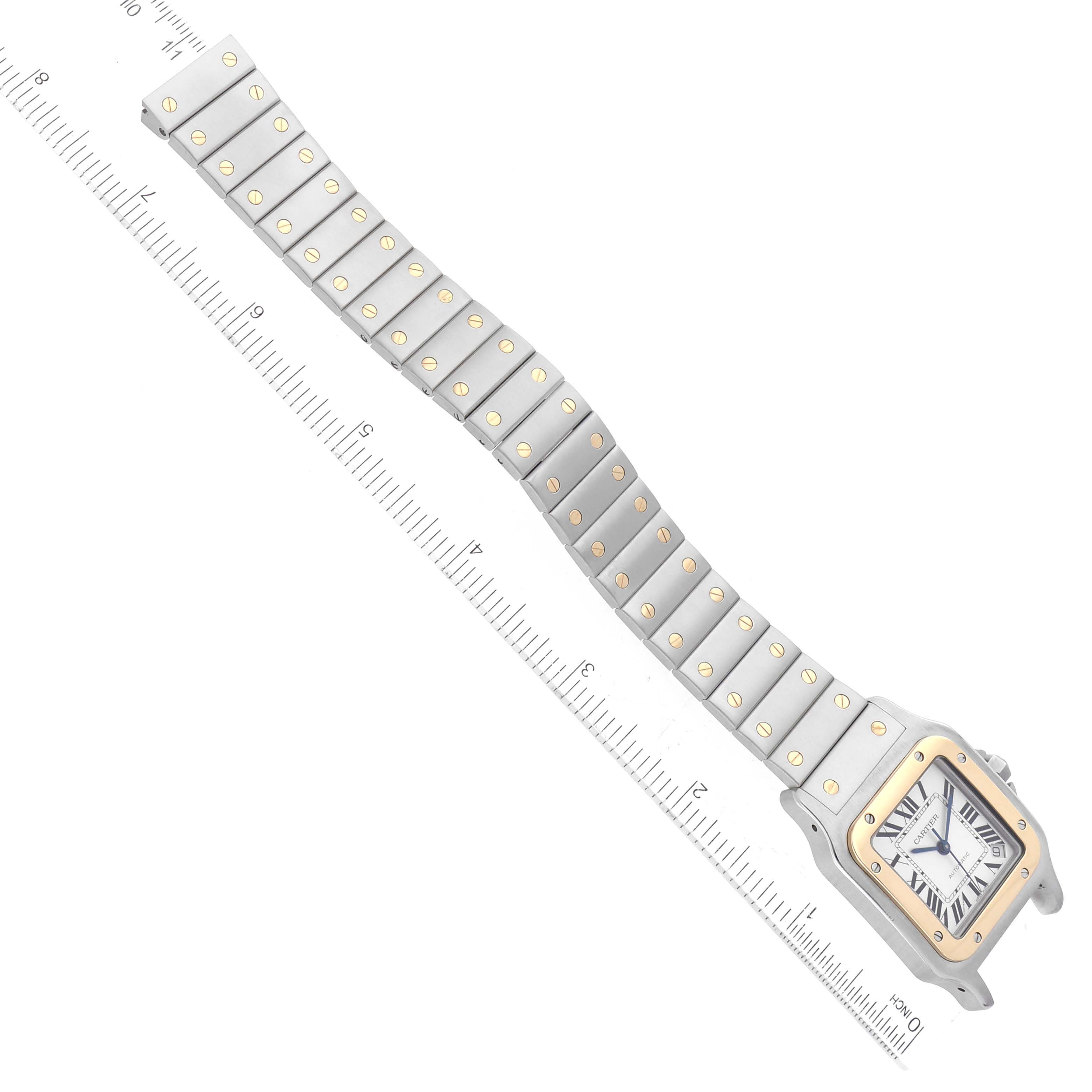 The image shows a top-down view of a Cartier Santos W20099C4 Men's Steel and Gold (two tone) Silver Dial W20099C4 Men's Steel and Gold (two tone) Silver Dial model watch, displaying the face and full-length metal bracelet with ruler measurements.