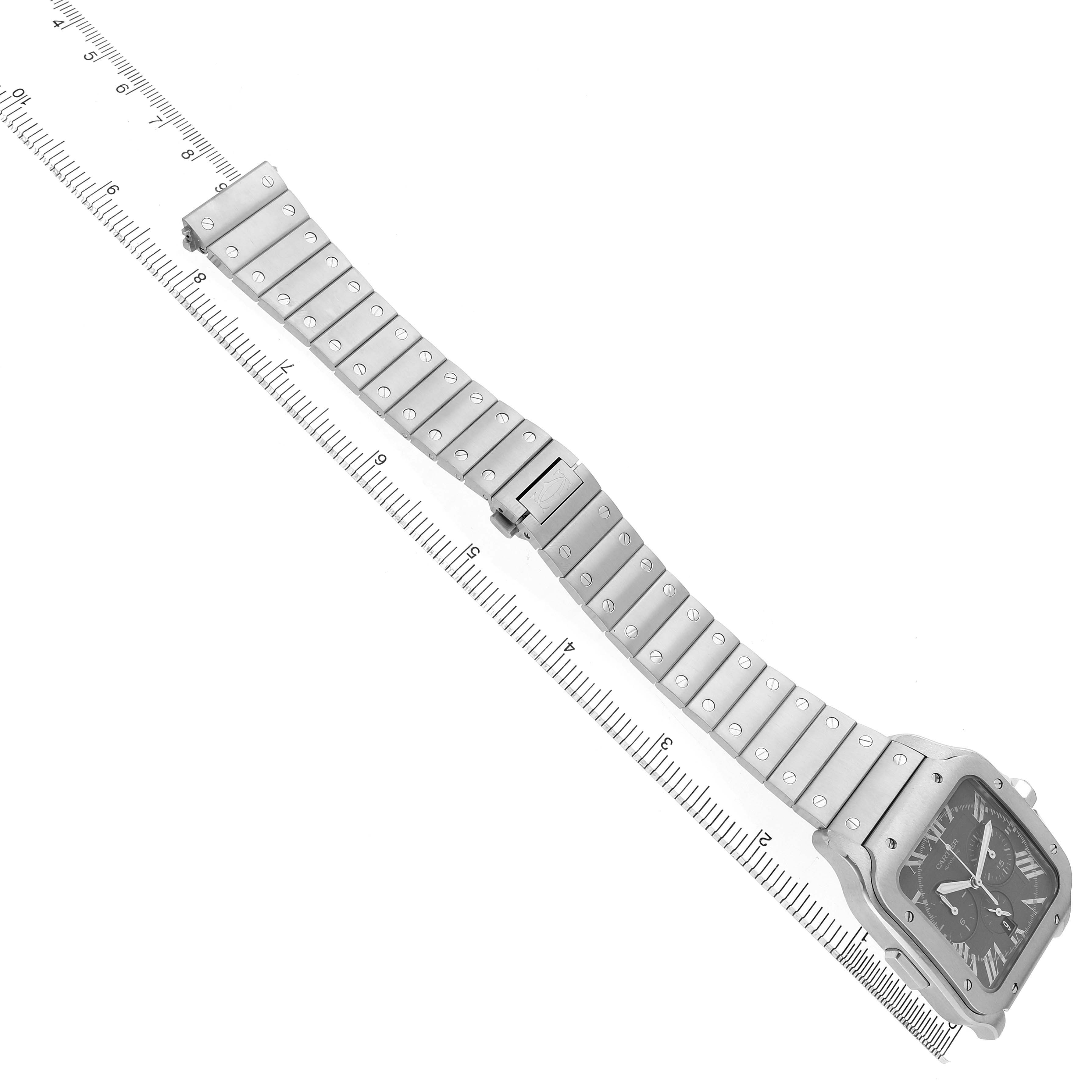 The image shows a Cartier Santos WSSA0078 Men's Stainless Steel Grey Dial watch at an angle displaying the metal bracelet and face, alongside a measuring ruler.
