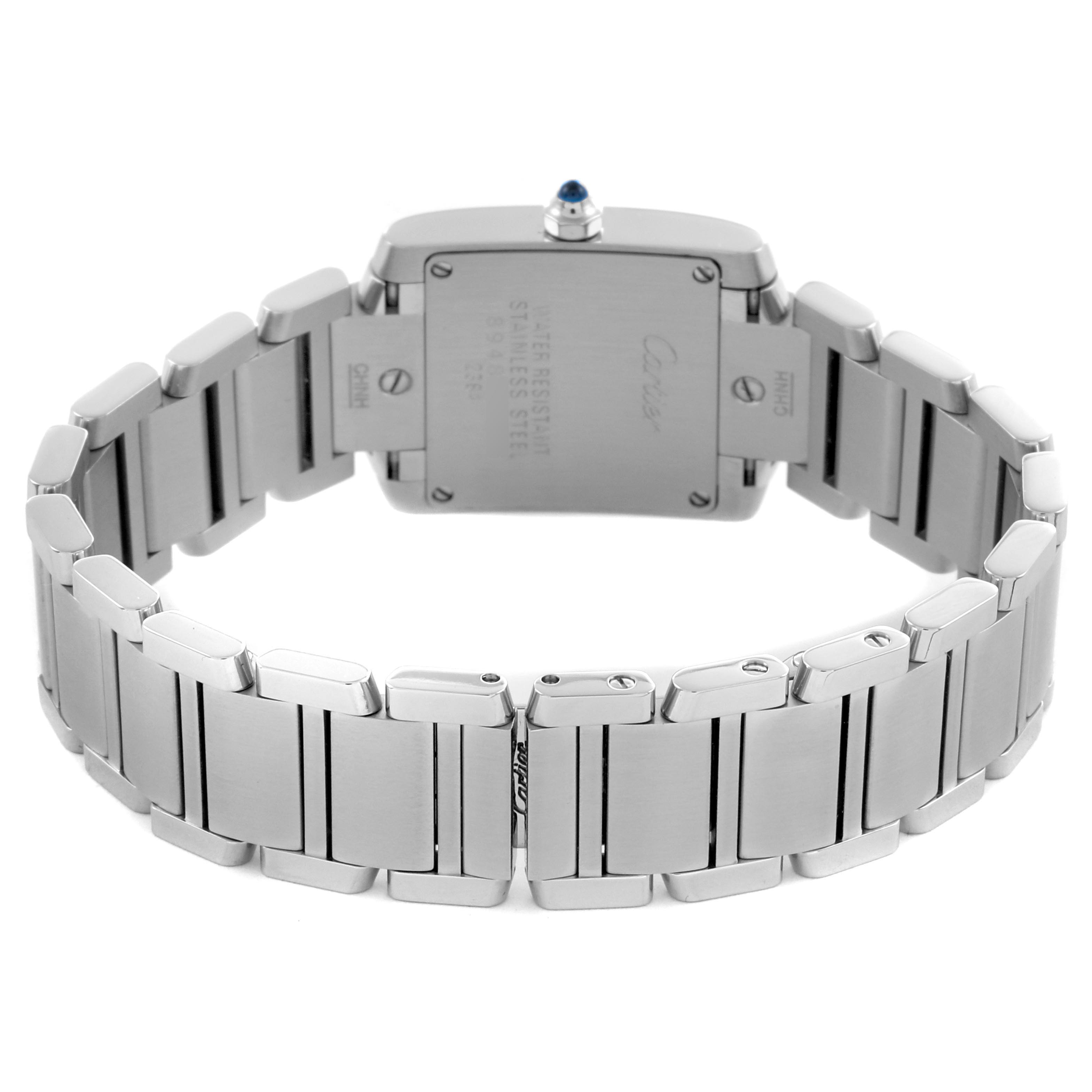 The Cartier Tank Française watch is shown from the back, highlighting the case back and stainless steel bracelet.