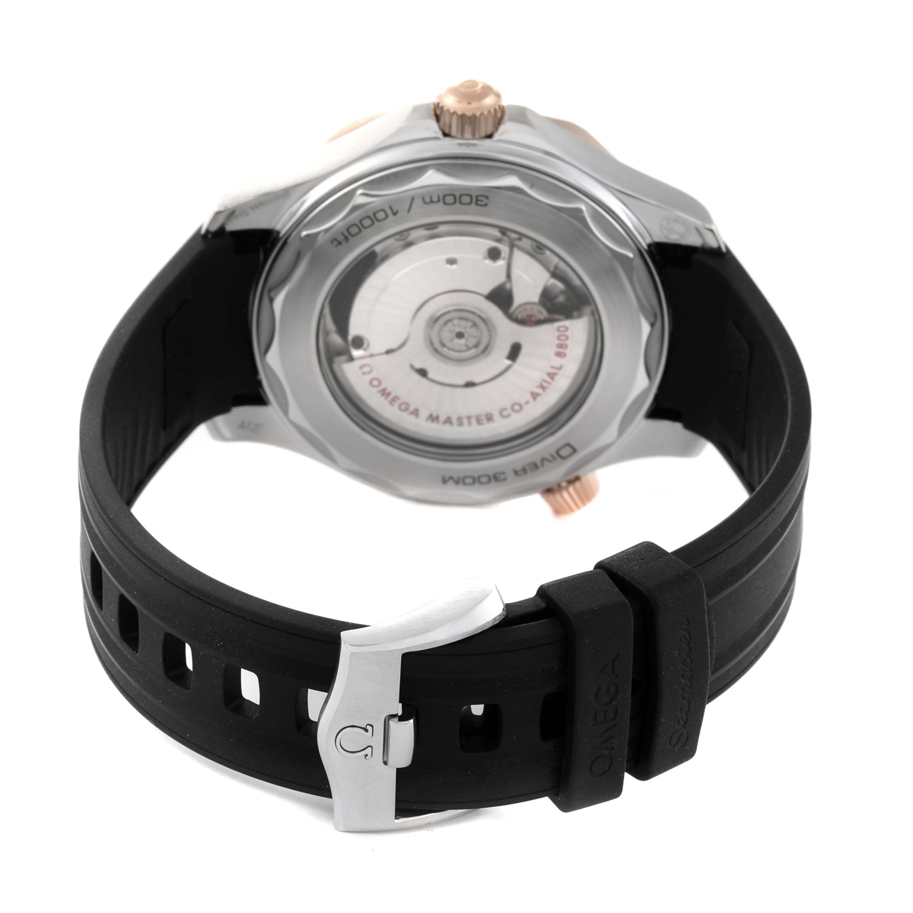 The image shows the back view of an Omega Seamaster 210.22.42.20.01.002 Men's Steel and Gold (two tone) Black Dial 210.22.42.20.01.002 Men's Steel and Gold (two tone) Black Dial watch, featuring its movement through a transparent case back and a black rubber strap with a buckle.