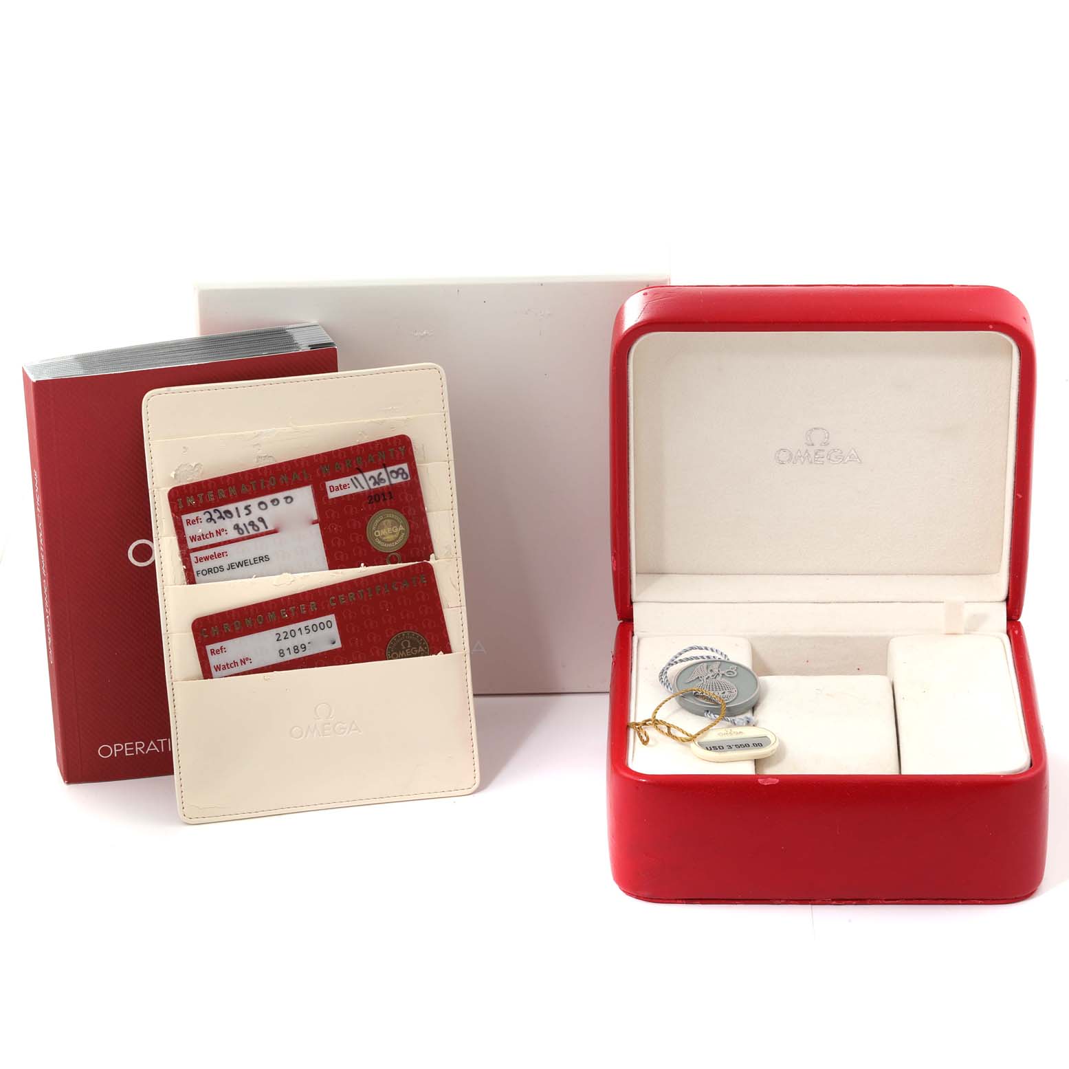 The image shows an Omega Planet Ocean 2201.50.00 Men
s Stainless Steel Black Dial 2201.50.00 Men
s Stainless Steel Black Dial watch box, a warranty cardholder, and an operating manual from a front angle.