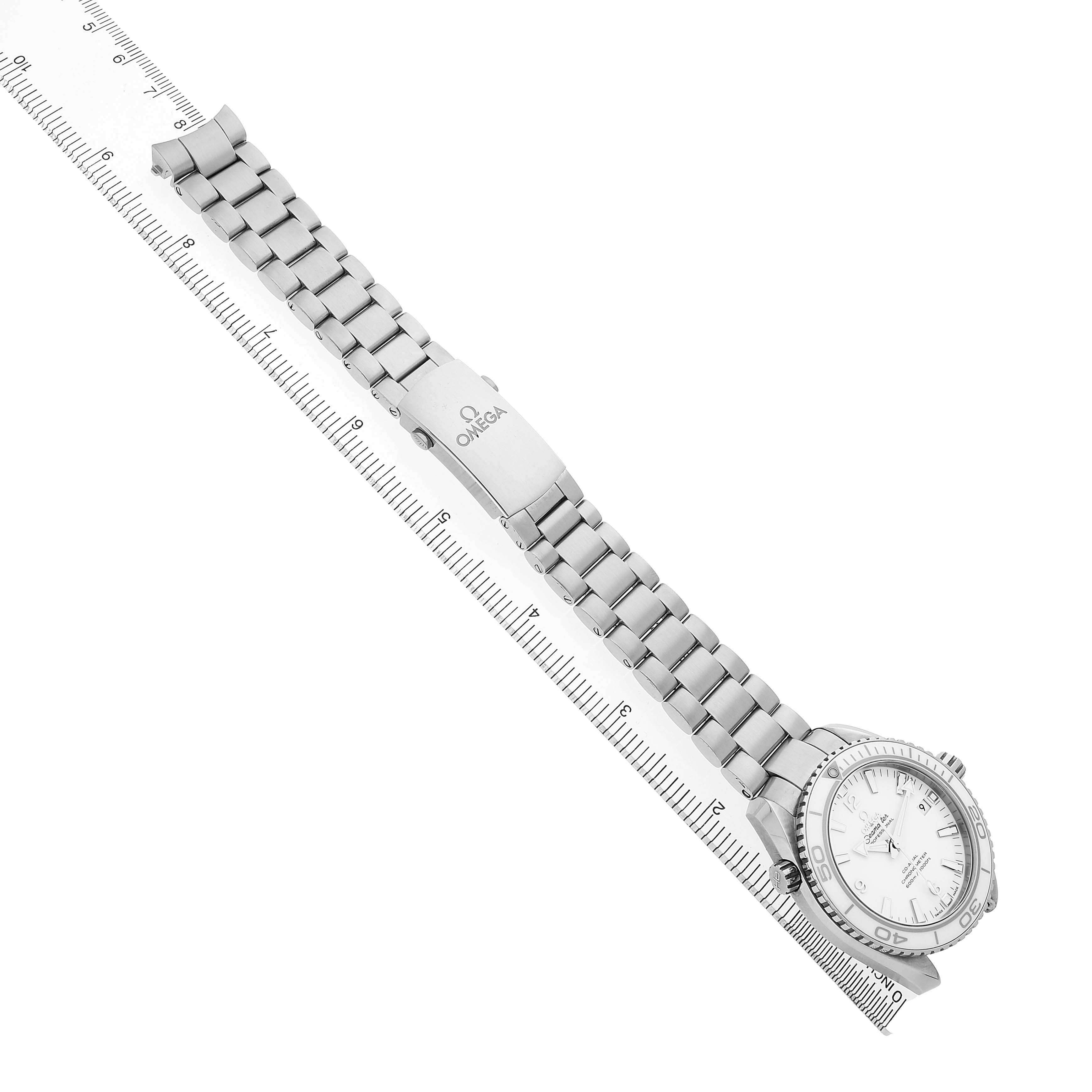 The Omega Seamaster 232.30.42.21.04.001 Men's Stainless Steel White Dial watch is shown at an angle displaying its bracelet, clasp, and face aligned next to a ruler.