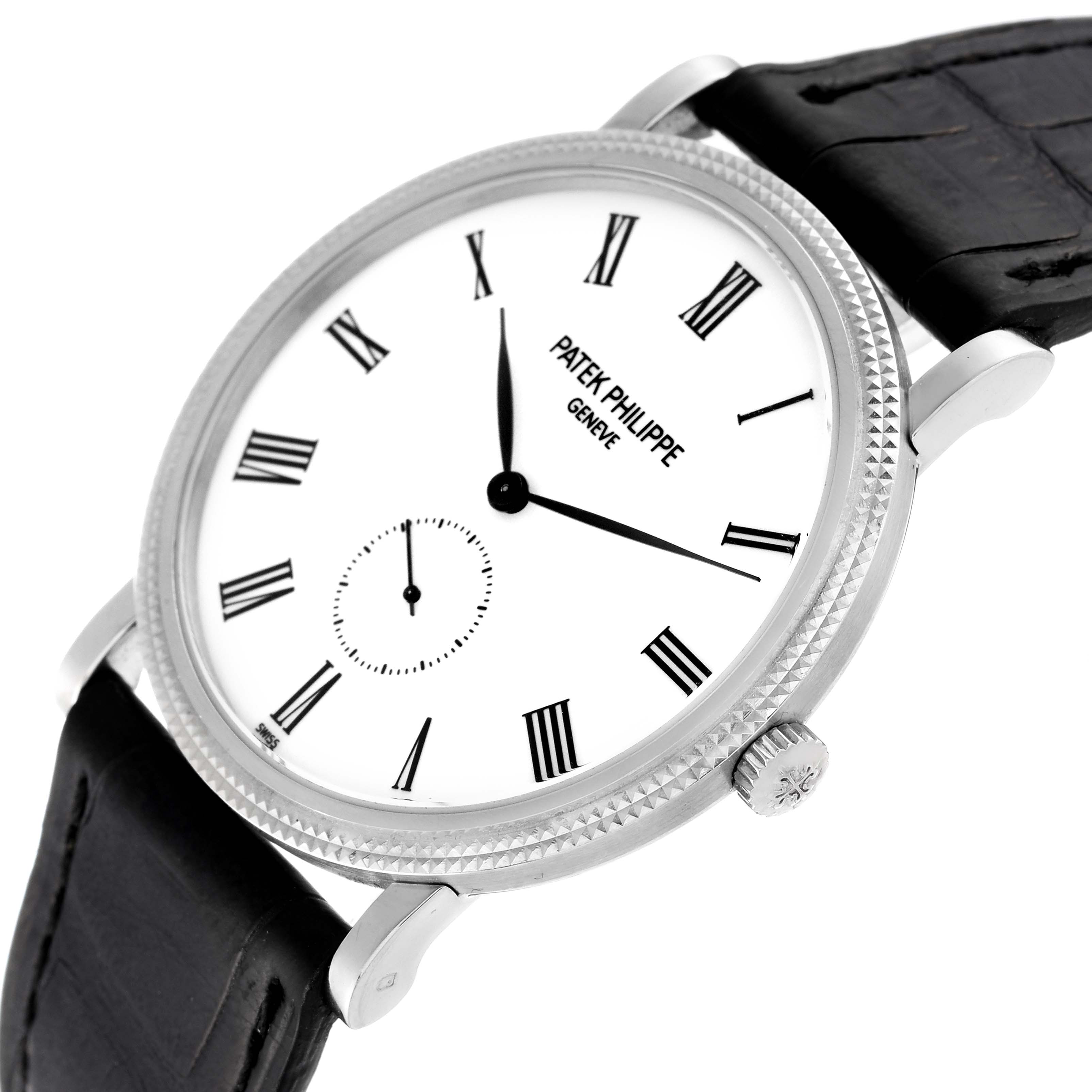 The image shows a Patek Philippe Calatrava 5119G-001 Men's White Gold White Dial 5119G-001 Men's White Gold White Dial watch, featuring a white dial with Roman numerals, and a black leather strap, viewed at an angle.