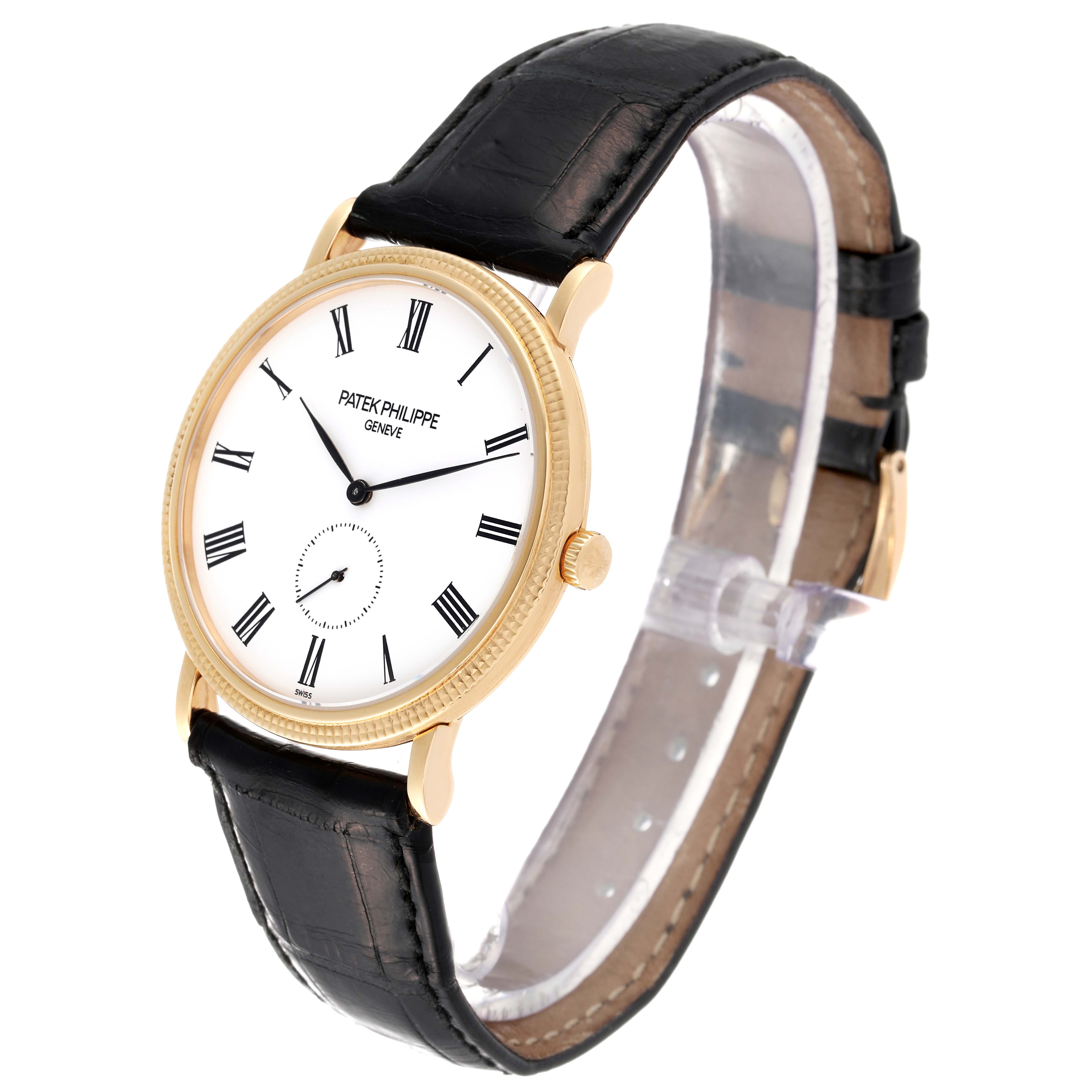 This image shows a Patek Philippe Calatrava 5119J Men's Yellow Gold White Dial 5119J Men's Yellow Gold White Dial watch at a three-quarter angle, highlighting its face, bezel, crown, and leather strap.