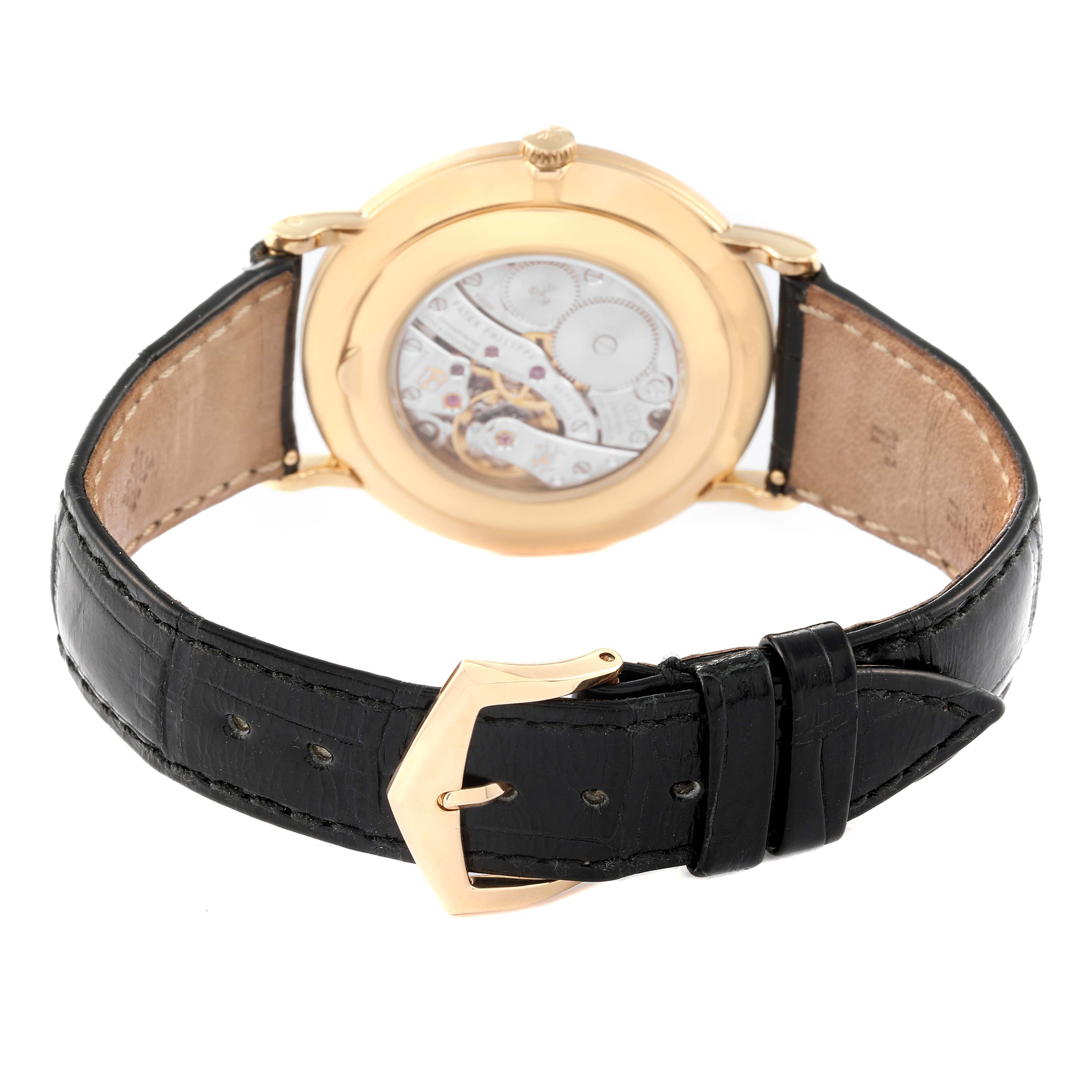This image shows the back view of a Patek Philippe Calatrava 5119J Men's Yellow Gold White Dial 5119J Men's Yellow Gold White Dial watch, highlighting its movement and black leather strap with a gold buckle.