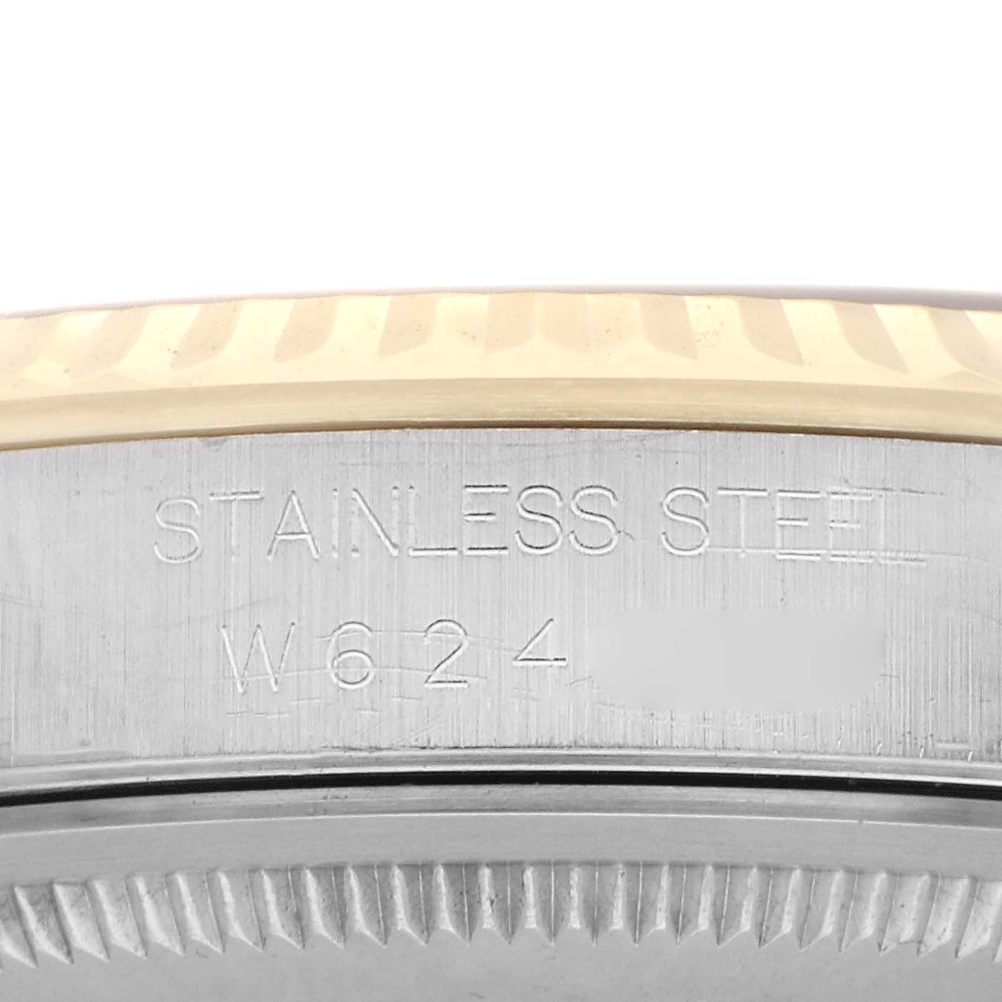 The image shows a close-up of the side engraving and fluted bezel of a Rolex Datejust 16233 Men's Steel and Gold (two tone) Champagne Dial 16233 Men's Steel and Gold (two tone) Champagne Dial watch, highlighting its stainless steel construction.