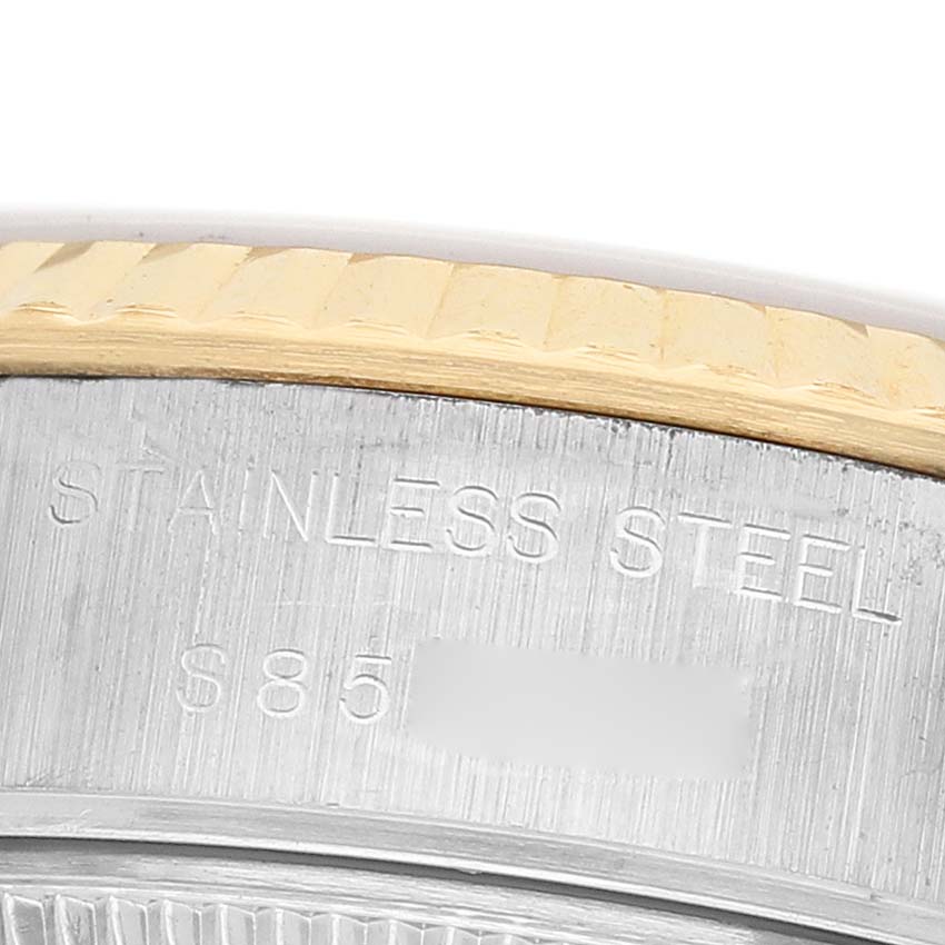 The image shows a close-up of the edge of a Rolex Datejust 69173 Women's Stainless Steel Champagne Dial watch, highlighting the stainless steel and part of the fluted bezel.