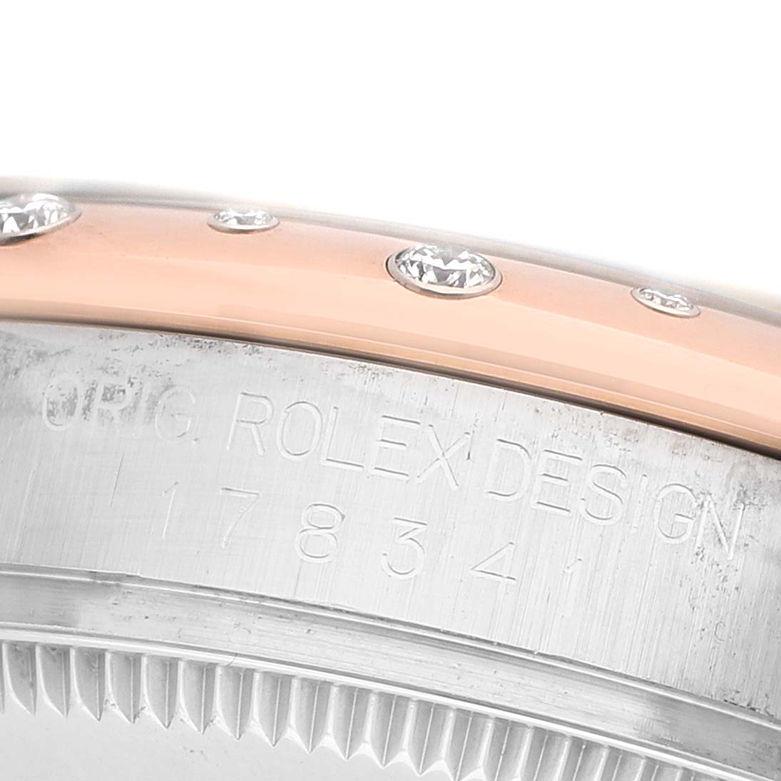 The image shows a close-up of the Rolex Datejust 178341 Women's Steel and Gold (two tone) Brown Dial model's bezel and case edge, featuring diamond accents and engraved inscriptions.