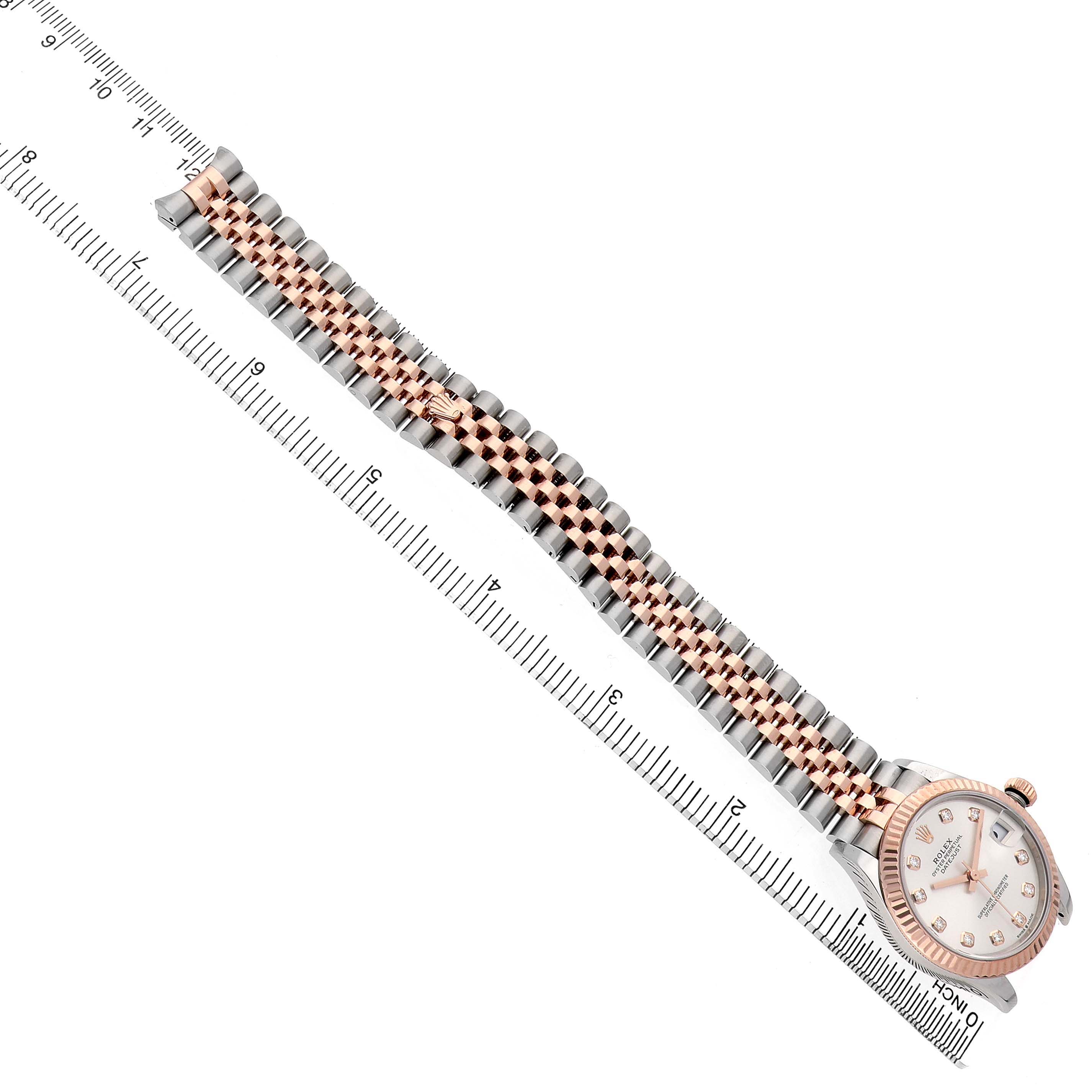 The Rolex Datejust 278271 Women's Stainless Steel Silver Dial watch is shown at an angled top view, highlighting the bracelet and dial along with a ruler for scale.