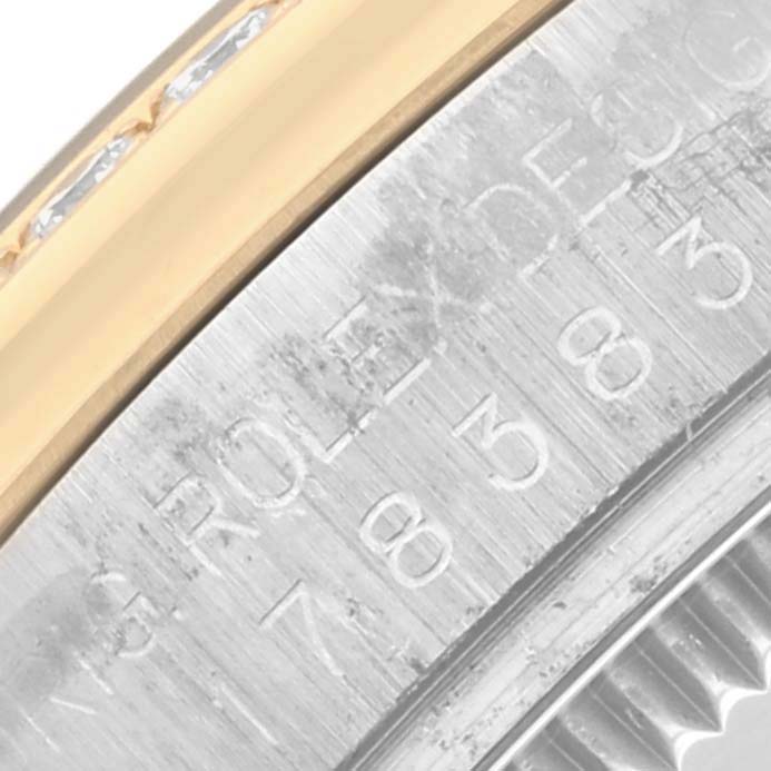 The image shows a close-up of a Rolex Datejust model, focusing on the engraved inner bezel and part of the fluted or smooth bezel.