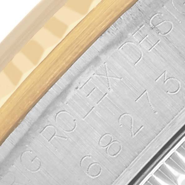 The image shows an angled close-up of the engraved inner bezel of a Rolex Mid-Size 68273 Women's Steel and Gold (two tone) Champagne Dial 68273 Women's Steel and Gold (two tone) Champagne Dial watch, highlighting part of the engraved text.
