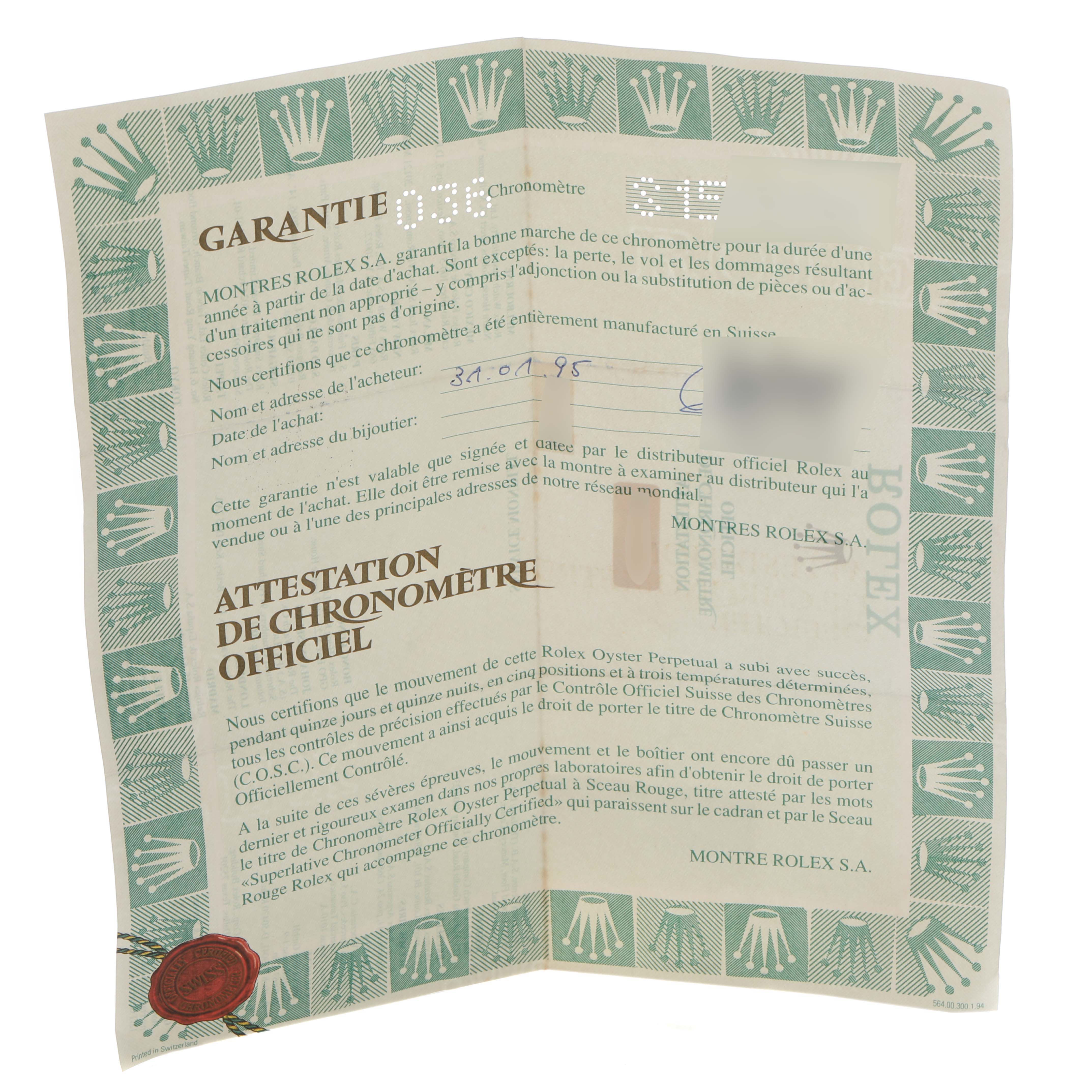 The image shows a Rolex certificate at an angle, featuring the warranty and chronometer attestation for a Mid-Size model.