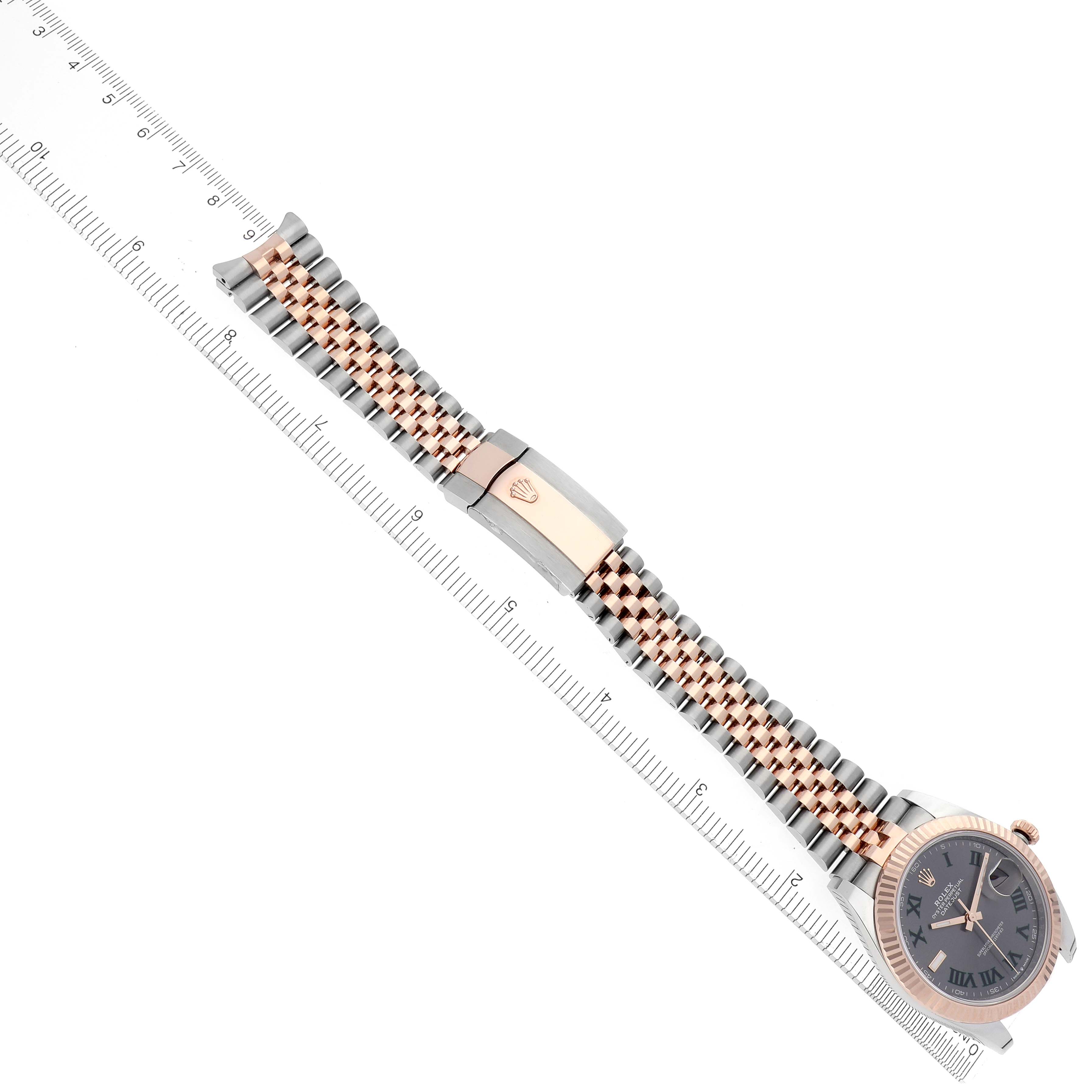 The image shows a Rolex Datejust 41 126331 Men
s Steel and Gold (two tone) Grey Dial 126331 Men
s Steel and Gold (two tone) Grey Dial watch at a diagonal angle, highlighting the bracelet and clasp beside a ruler.