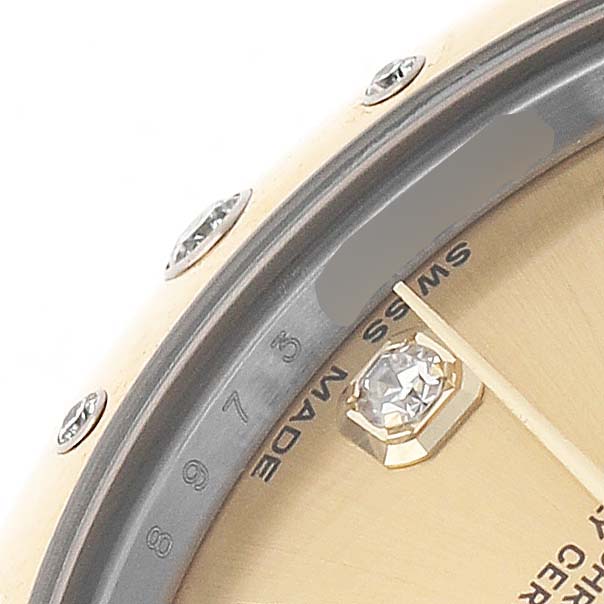 The image shows a close-up of the bezel, chapter ring, and part of the dial of a Mid-Size Rolex watch.