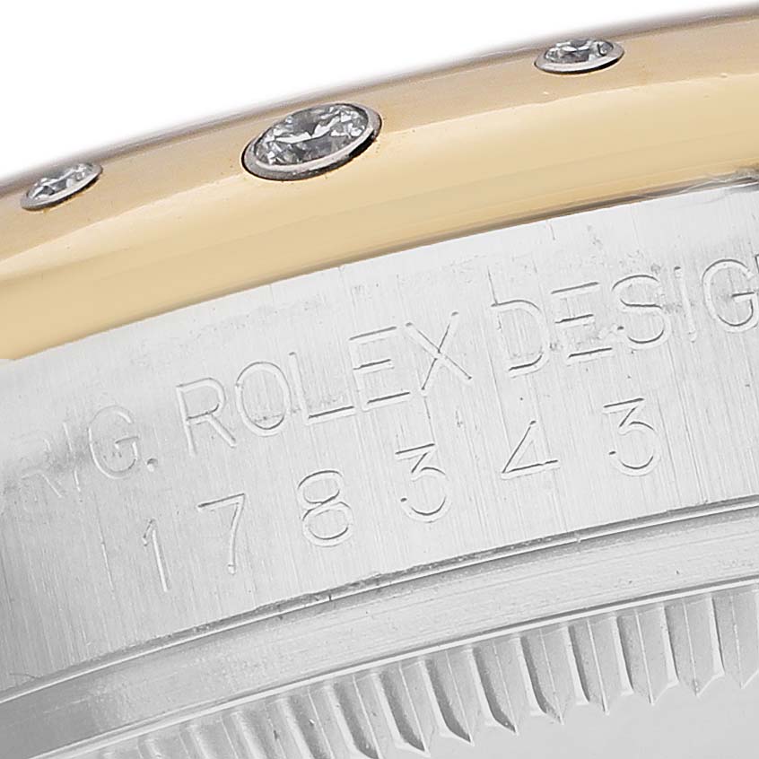 The image shows a detailed side view of a Rolex Mid-Size 178343 Women's Steel and Gold (two tone) Champagne Dial model with part of the bezel and engraved markings.