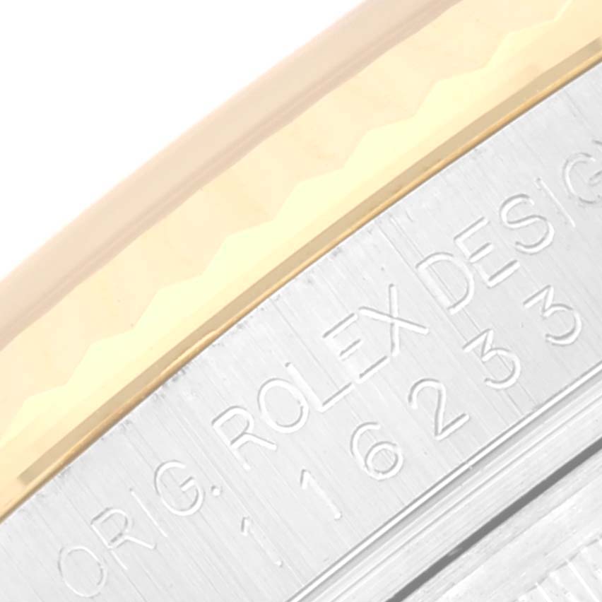 The image shows a close-up of the side engraving and part of the bezel on a Rolex Datejust 116233 Men's Steel and Gold (two tone) Black Dial 116233 Men's Steel and Gold (two tone) Black Dial watch.