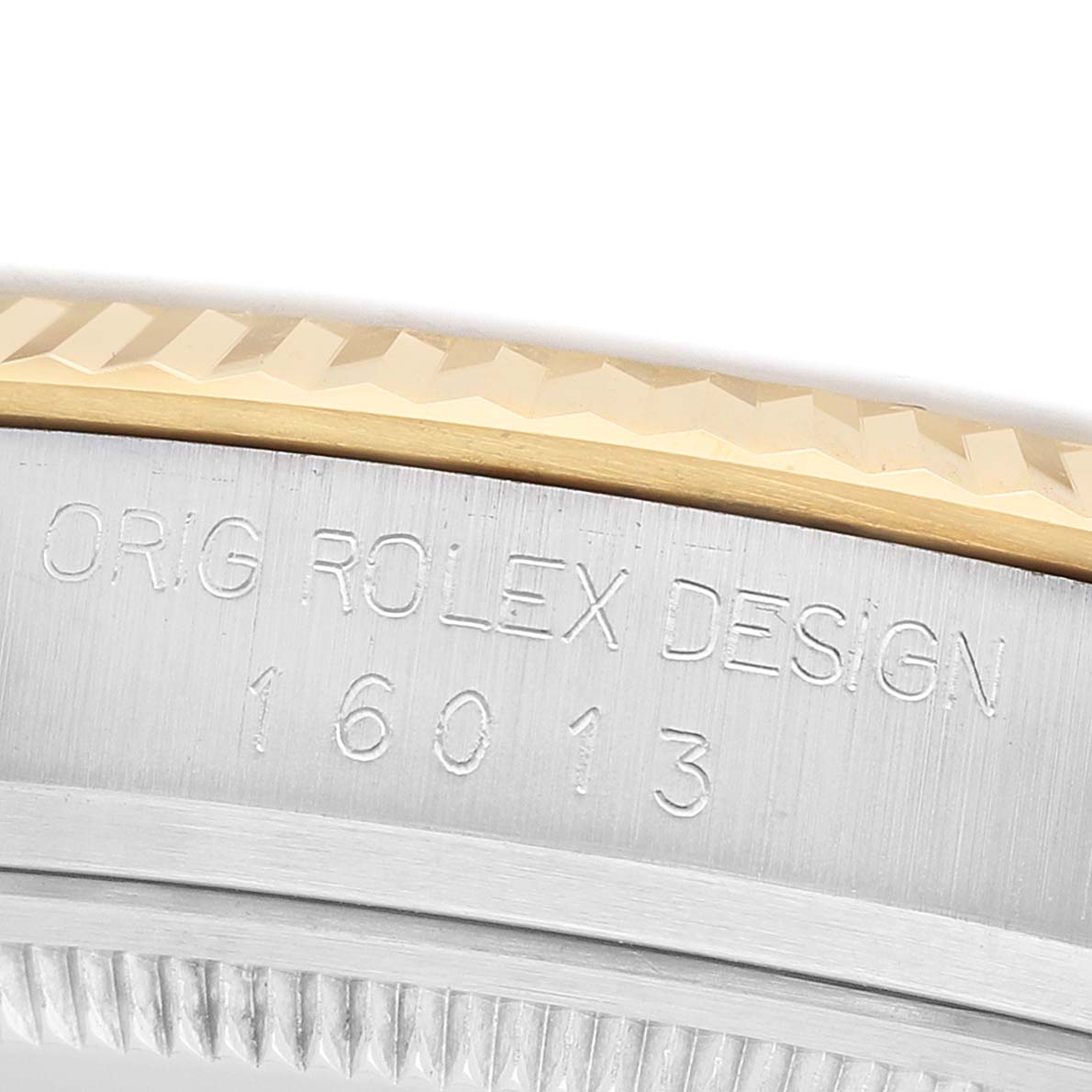 This image shows a close-up of the edge and engraved details of a Rolex Datejust 16013 Men's Steel and Gold (two tone) Champagne Dial watch bezel.