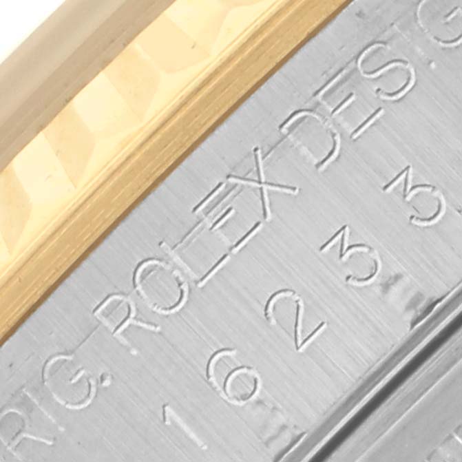 The image shows an angled close-up of the Rolex Datejust 16233 Men's Steel and Gold (two tone) Silver Dial 16233 Men's Steel and Gold (two tone) Silver Dial model's engraved case edge and fluted bezel.