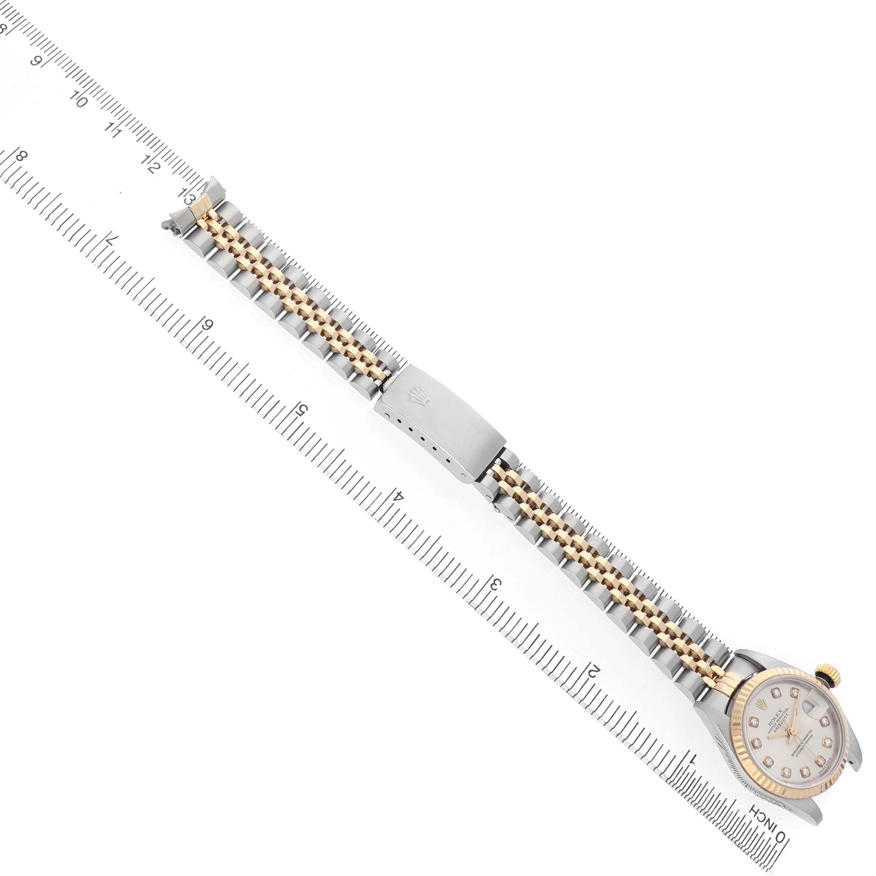 The image shows a Rolex Datejust 79173 Women's Stainless Steel Silver Dial watch laid flat, highlighting its bracelet and clasp next to a measuring ruler for scale.