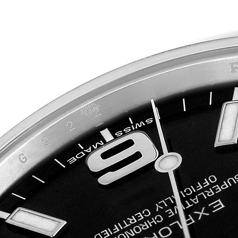 This close-up angle of the Rolex Explorer 214270 Men
s Stainless Steel Black Dial 214270 Men
s Stainless Steel Black Dial watch shows part of the dial with the number 9, minute markers, and text.