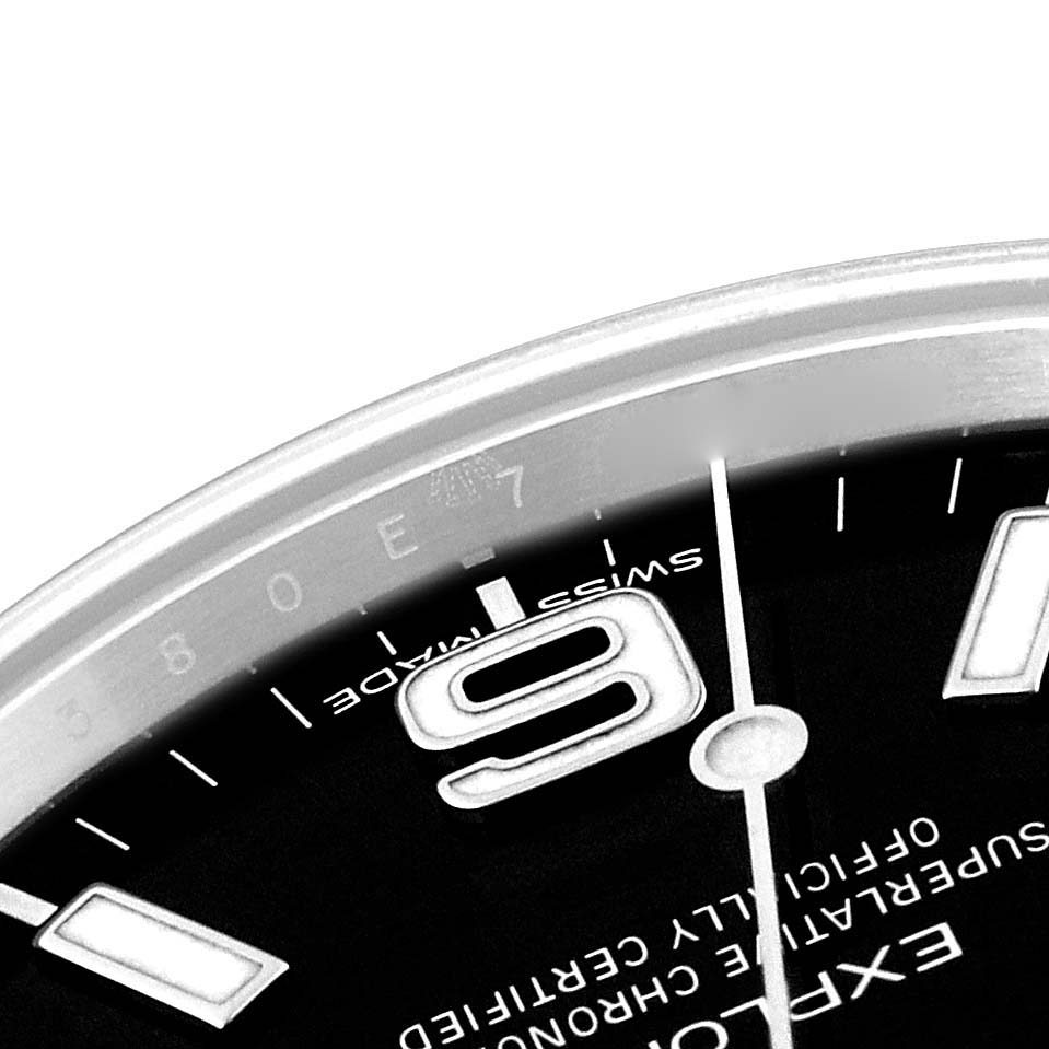 The image shows a close-up of the Rolex Explorer 214270 Men
s Stainless Steel Black Dial 214270 Men
s Stainless Steel Black Dial
s dial, specifically the "Swiss Made" marking, part of the numeral "9," and part of the second hand.