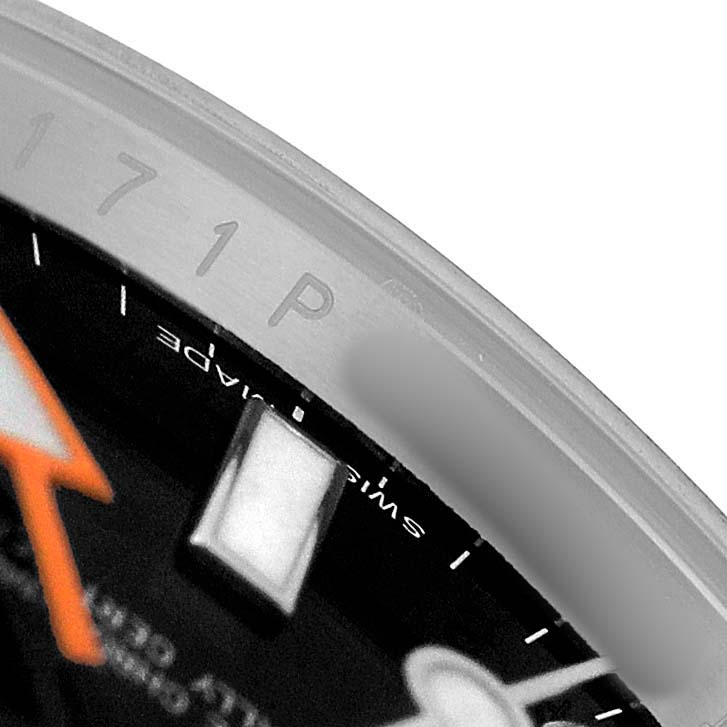 The image shows a close-up of the bezel edge and dial of a Rolex Explorer 216570 Men's Stainless Steel Black Dial watch, highlighting the engravings and markers.