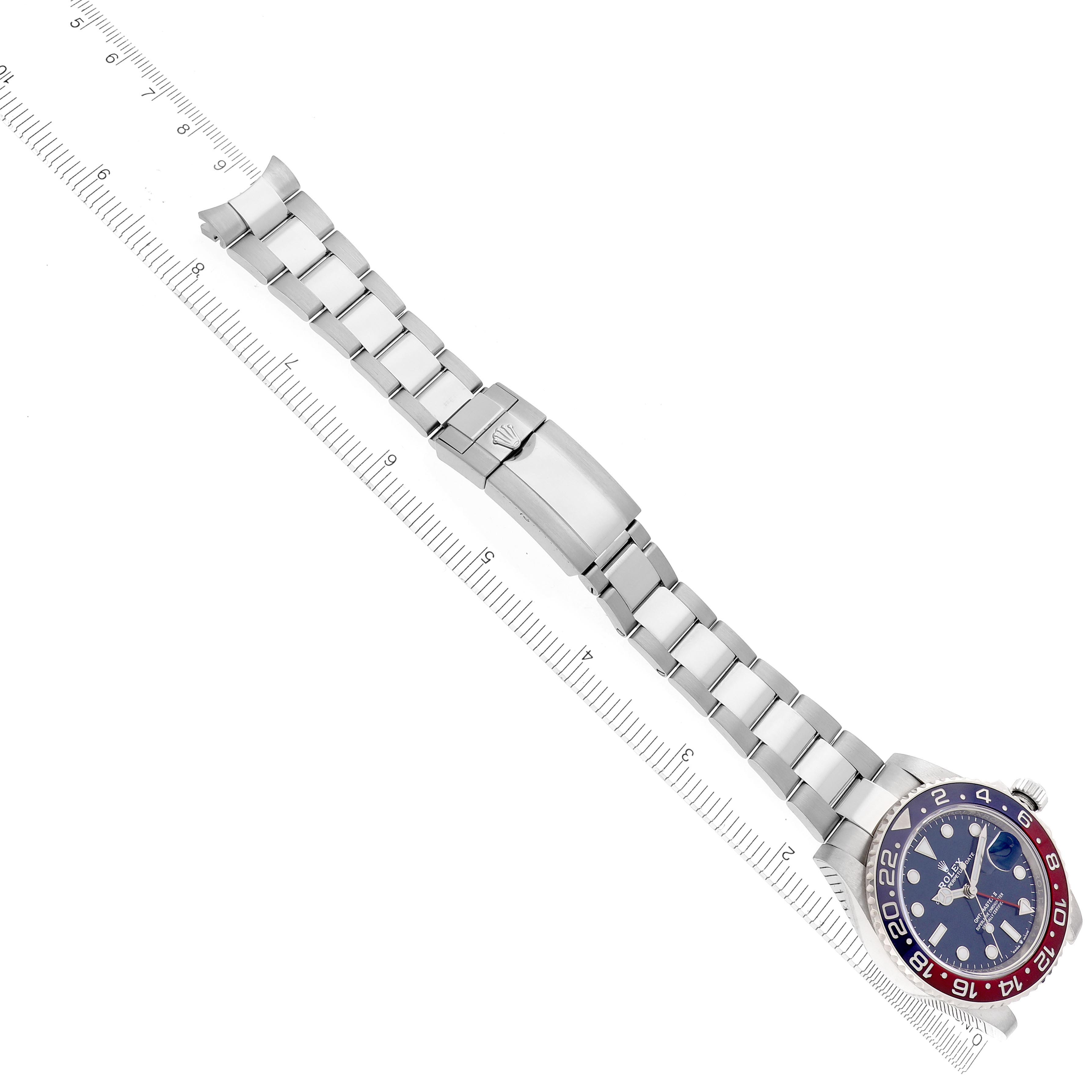 The Rolex GMT-Master 126719 Men's White Gold Blue Dial 126719 Men's White Gold Blue Dial watch is shown from an angled top view, displaying the full bracelet, clasp, and bezel, alongside a ruler for scale.