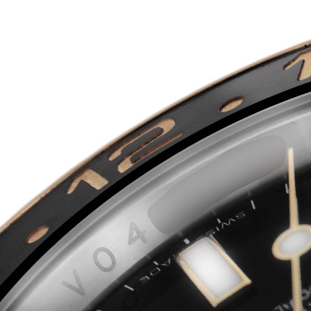 This close-up of the Rolex GMT-Master 116713 Men's Steel and Gold (two tone) Black Dial 116713 Men's Steel and Gold (two tone) Black Dial shows the bezel, a portion of the dial, and the number 12.