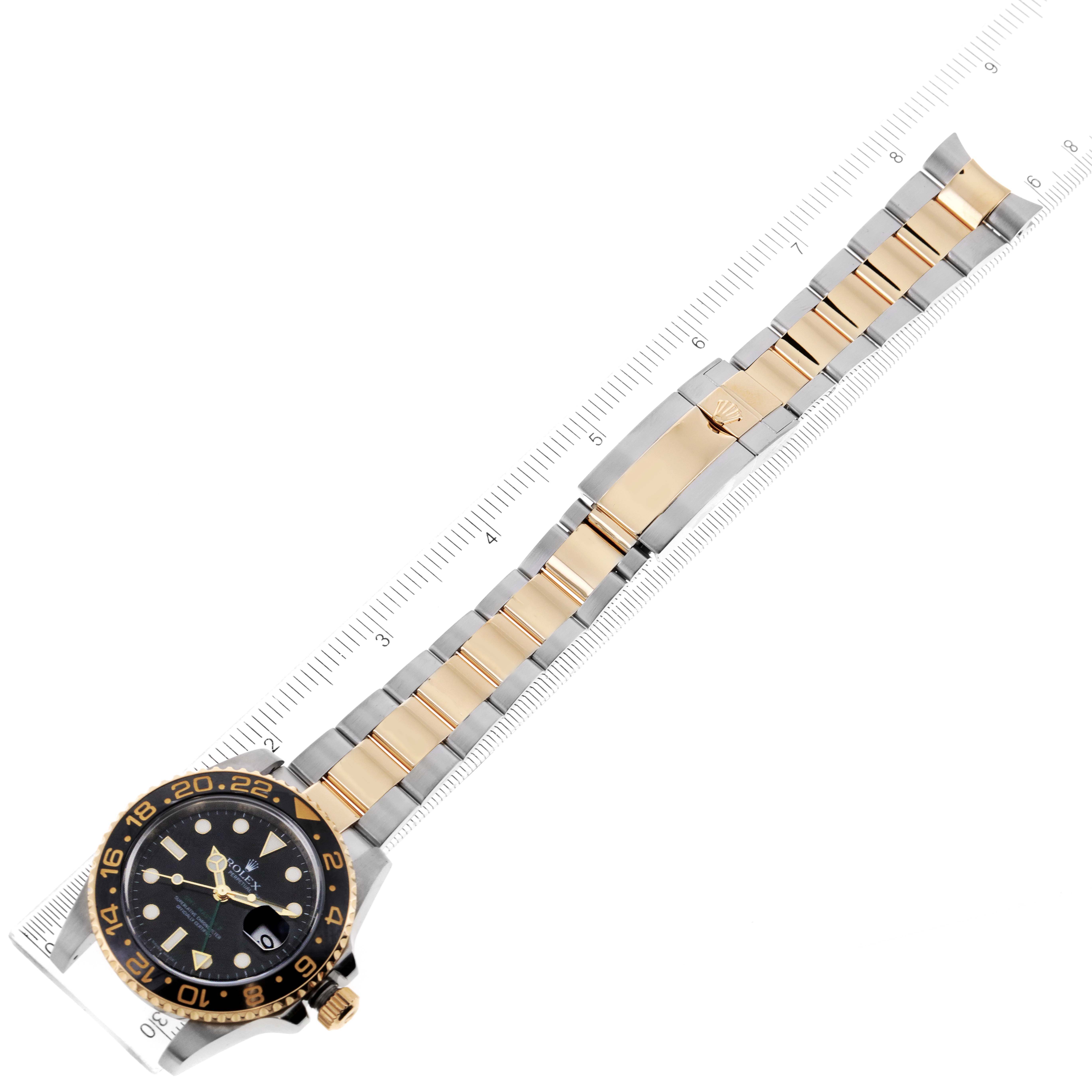This image shows a top-down view of a Rolex GMT-Master 116713 Men's Steel and Gold (two tone) Black Dial 116713 Men's Steel and Gold (two tone) Black Dial watch, highlighting the face, bezel, and band with a ruler for measurement.