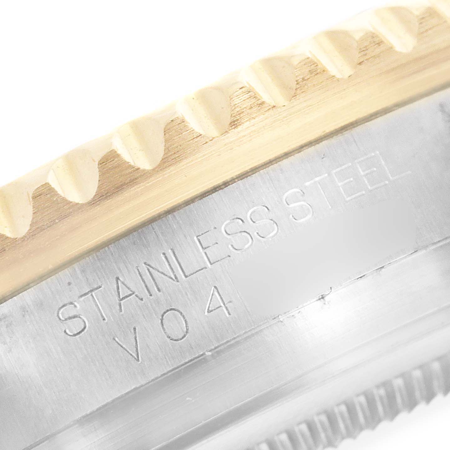 This close-up angled image of a Rolex GMT-Master 116713 Men's Steel and Gold (two tone) Black Dial 116713 Men's Steel and Gold (two tone) Black Dial watch shows the edge of the bezel and the engraved "STAINLESS STEEL" text.