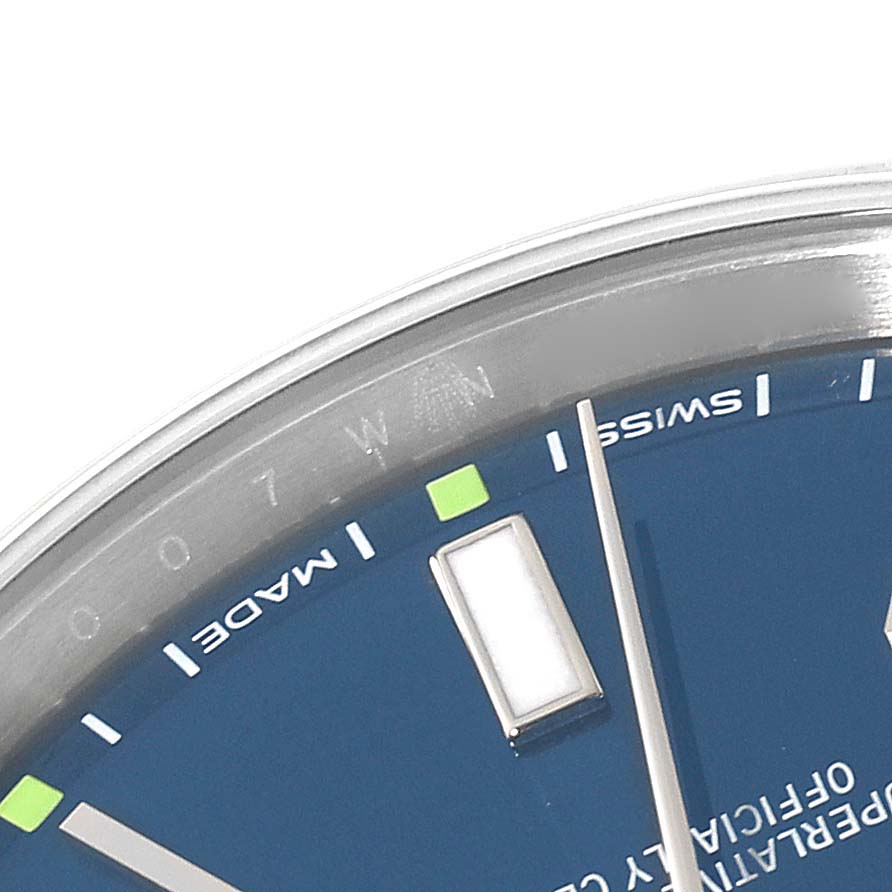This image shows a close-up angle of the dial and bezel of a blue Rolex Oyster Perpetual 114300 Men's Stainless Steel Blue Dial 114300 Men's Stainless Steel Blue Dial watch.